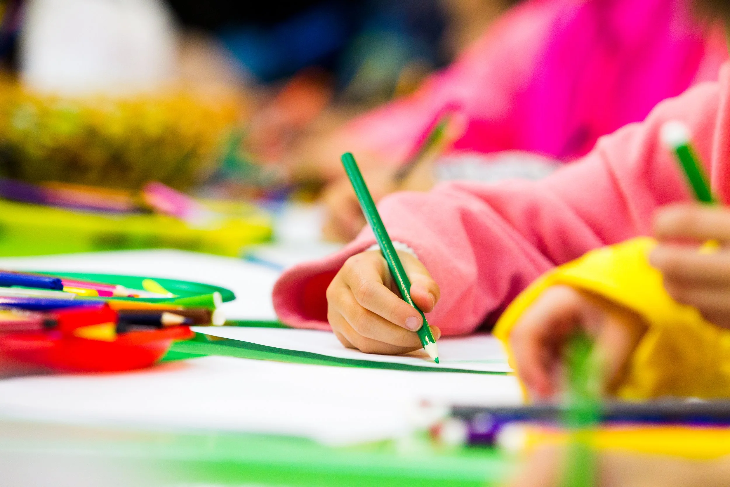 close-up image of a young artist working with coloured pencils