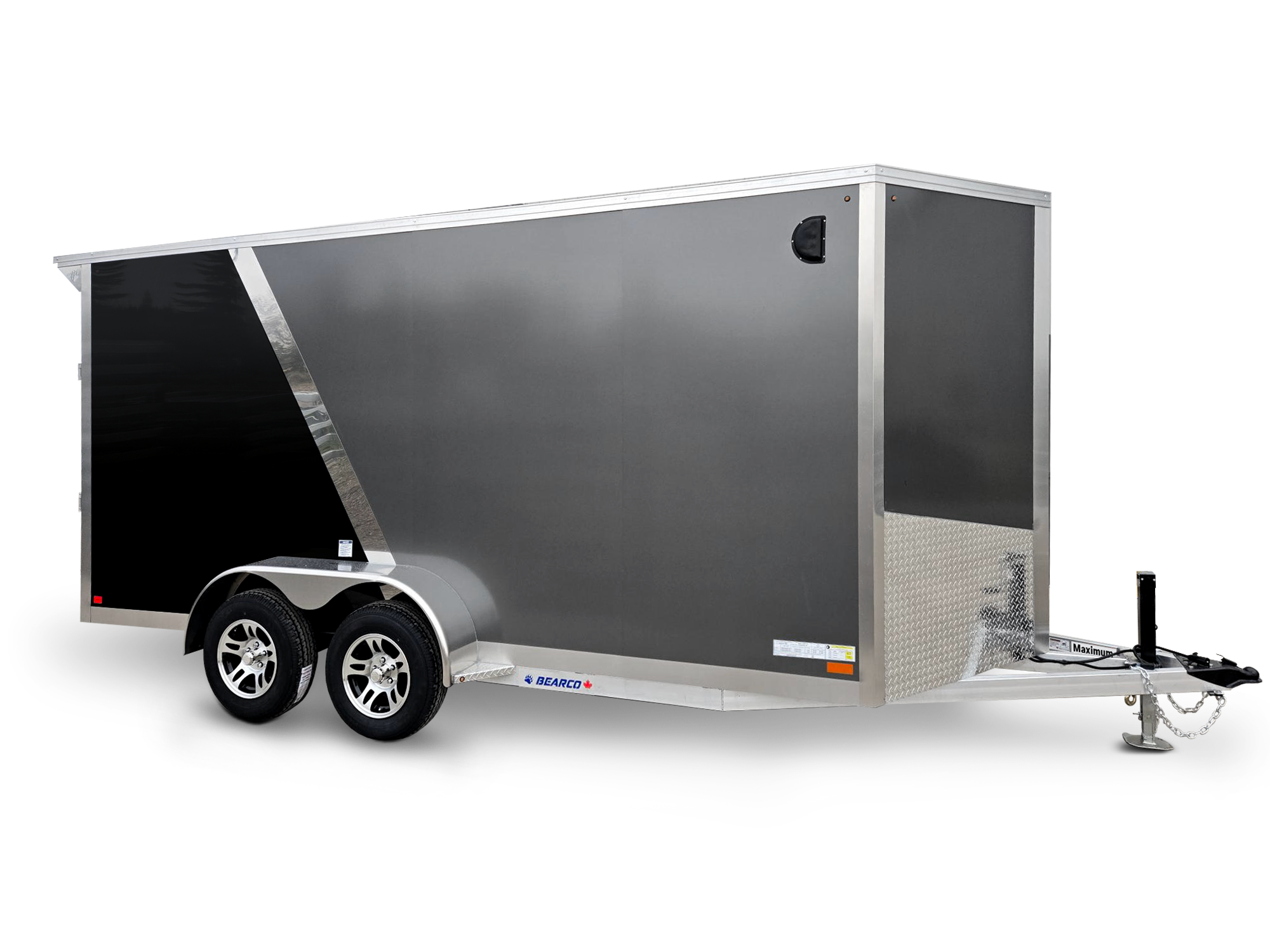 Silver and black enclosed cargo trailer with dual axles and a hitch, isolated on a black background.