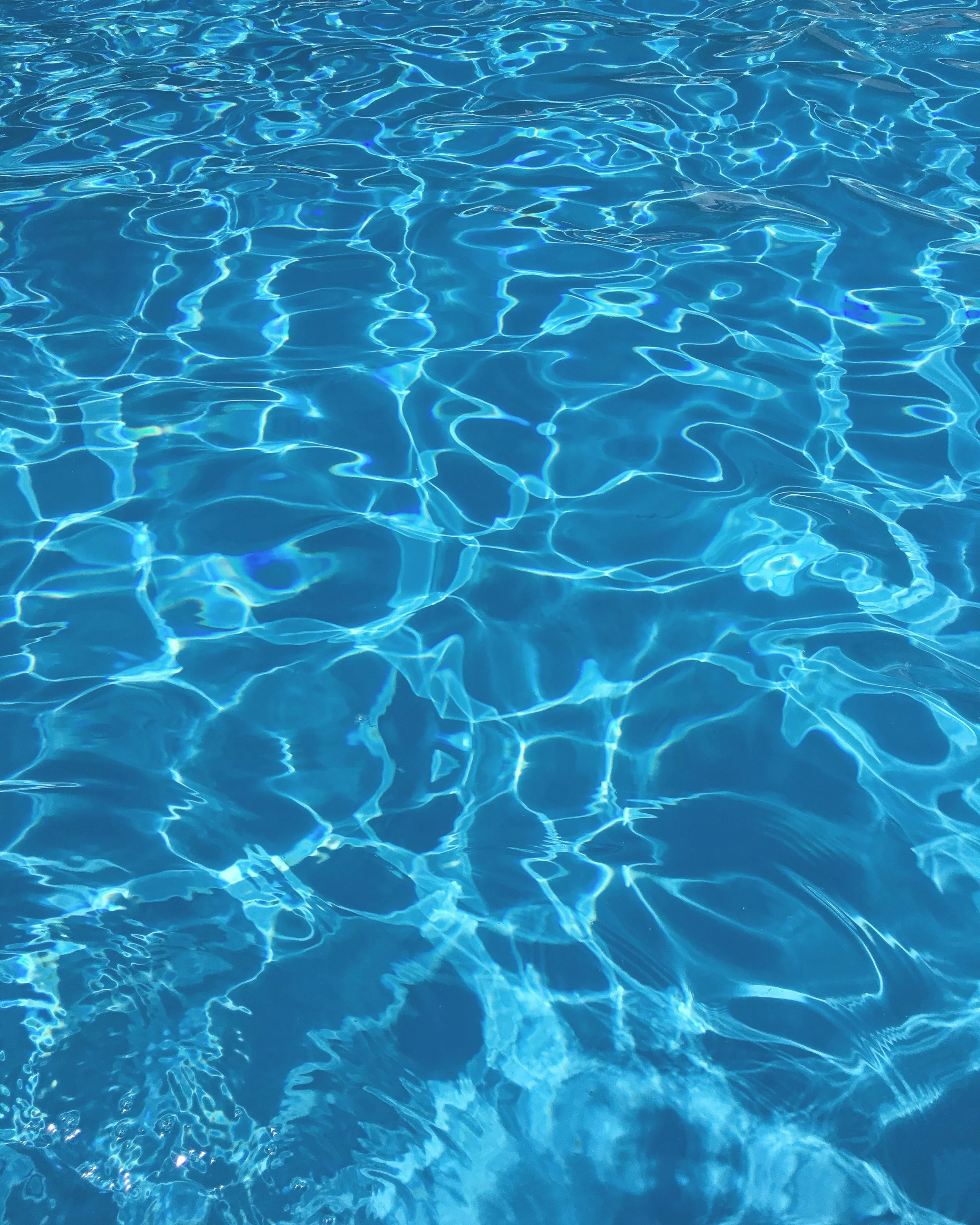 Blue swimming pool water with reflections and ripples