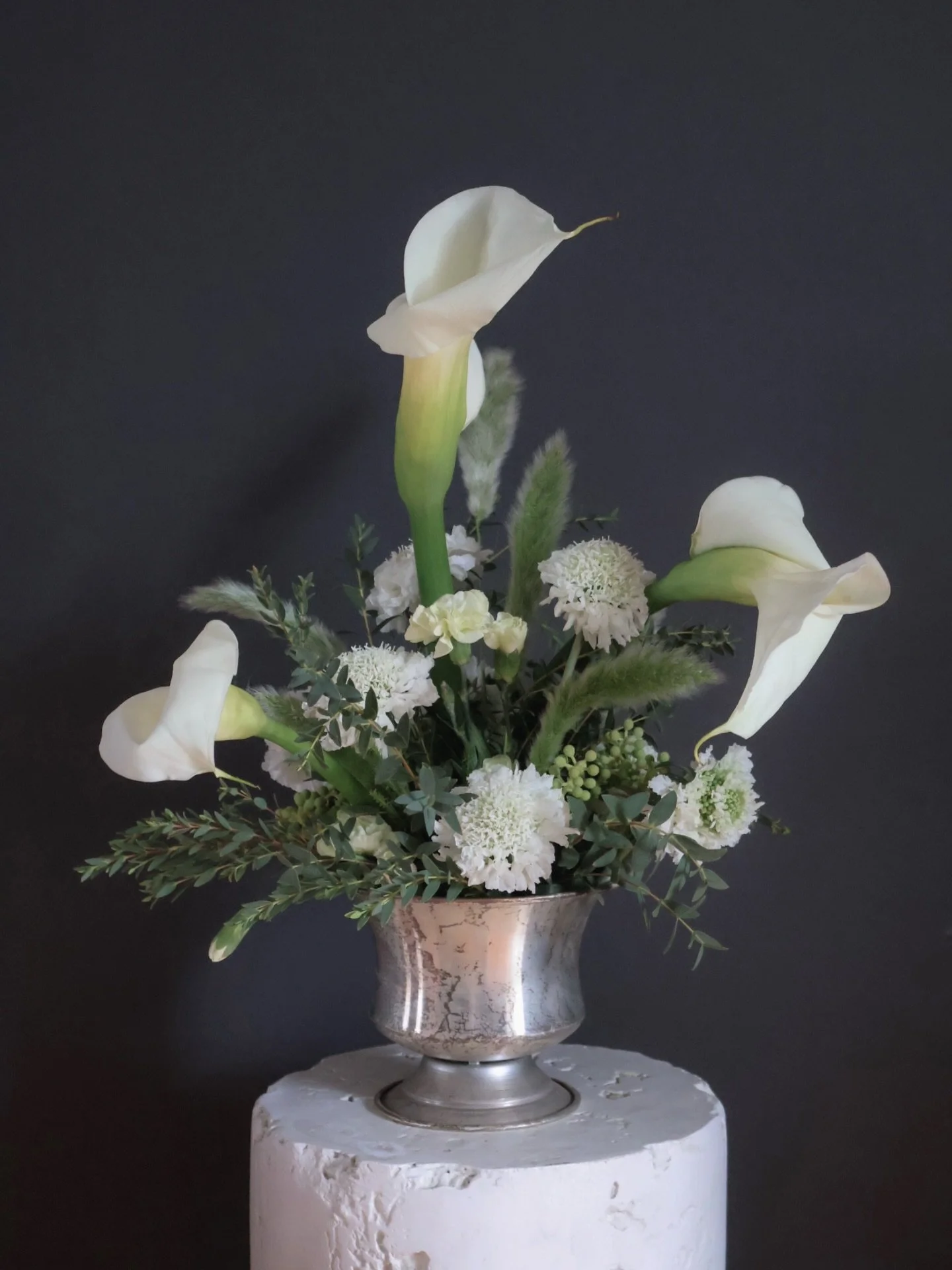Not everything is meant to be full.

Some arrangements are designed to breathe;
to let each stem have space,
to allow form and movement to lead.

Calla lilies were chosen intentionally here,
not to blend in, but to define the shape of the piece.

Les