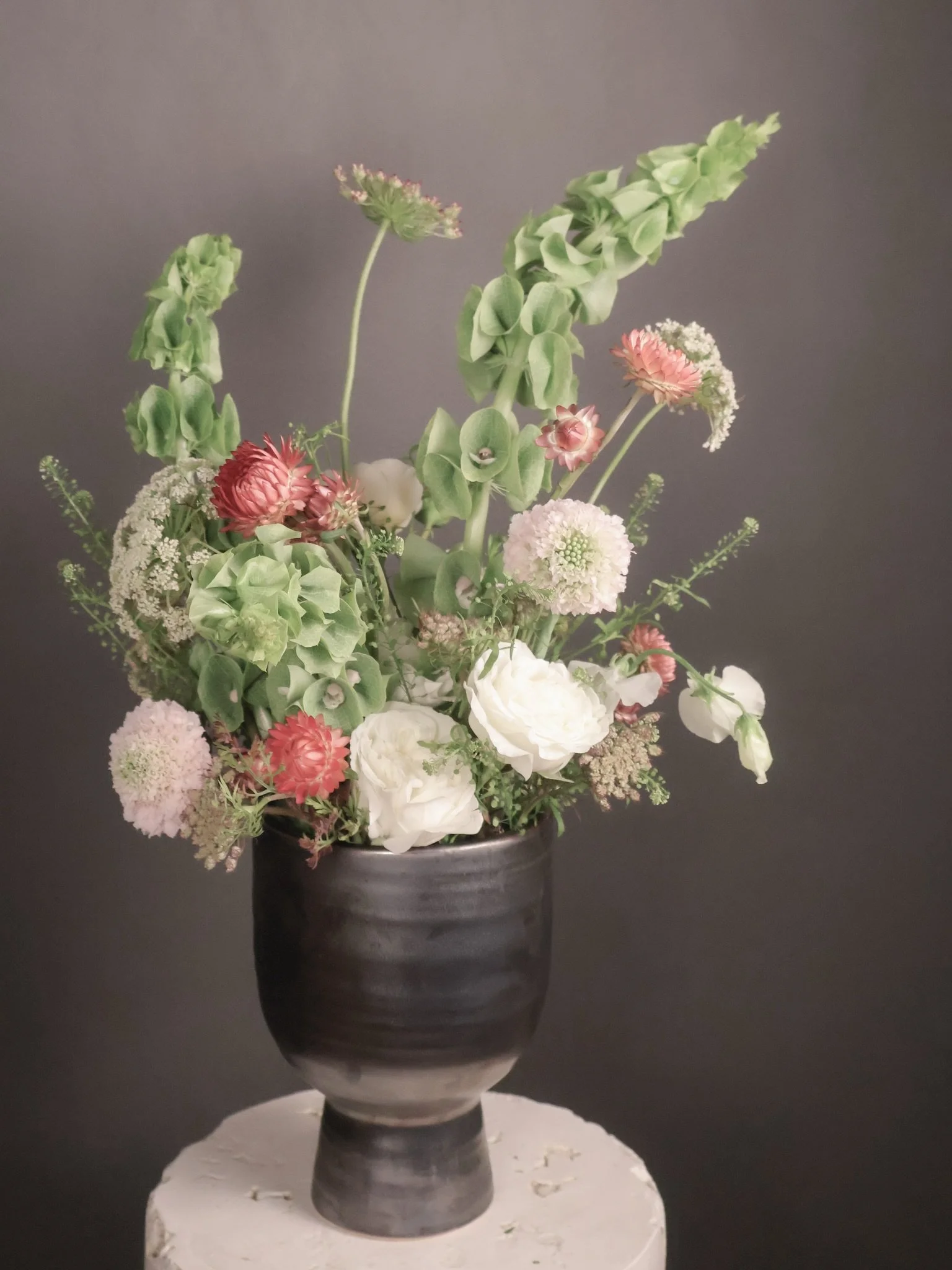 No two subscription arrangements are ever the same.

Each week is designed around what feels most alive, most interesting, and most beautiful in the season at that moment.

Papery strawflower, sculptural bells of Ireland, delicate blush scabiosa, gar