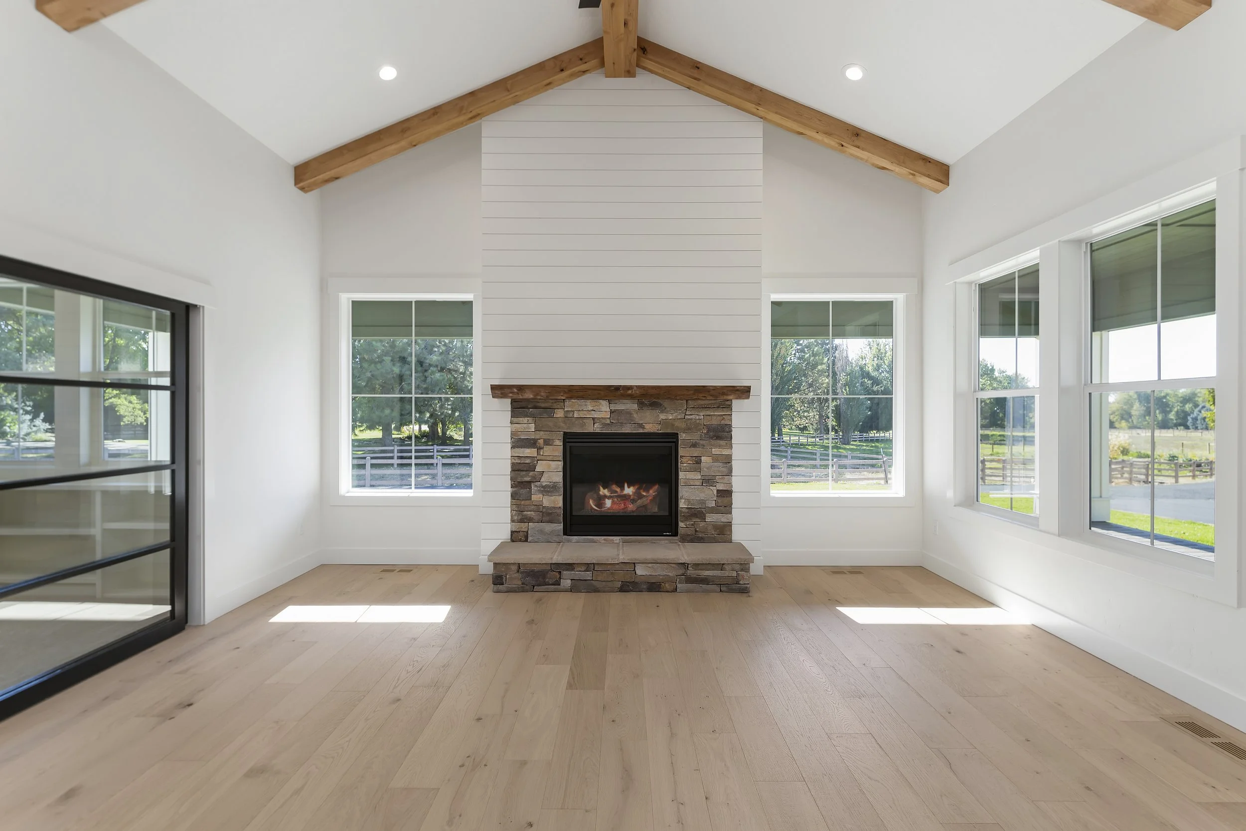 Living room fireplace, white walls, exposed beams,  custom home Boise Idaho