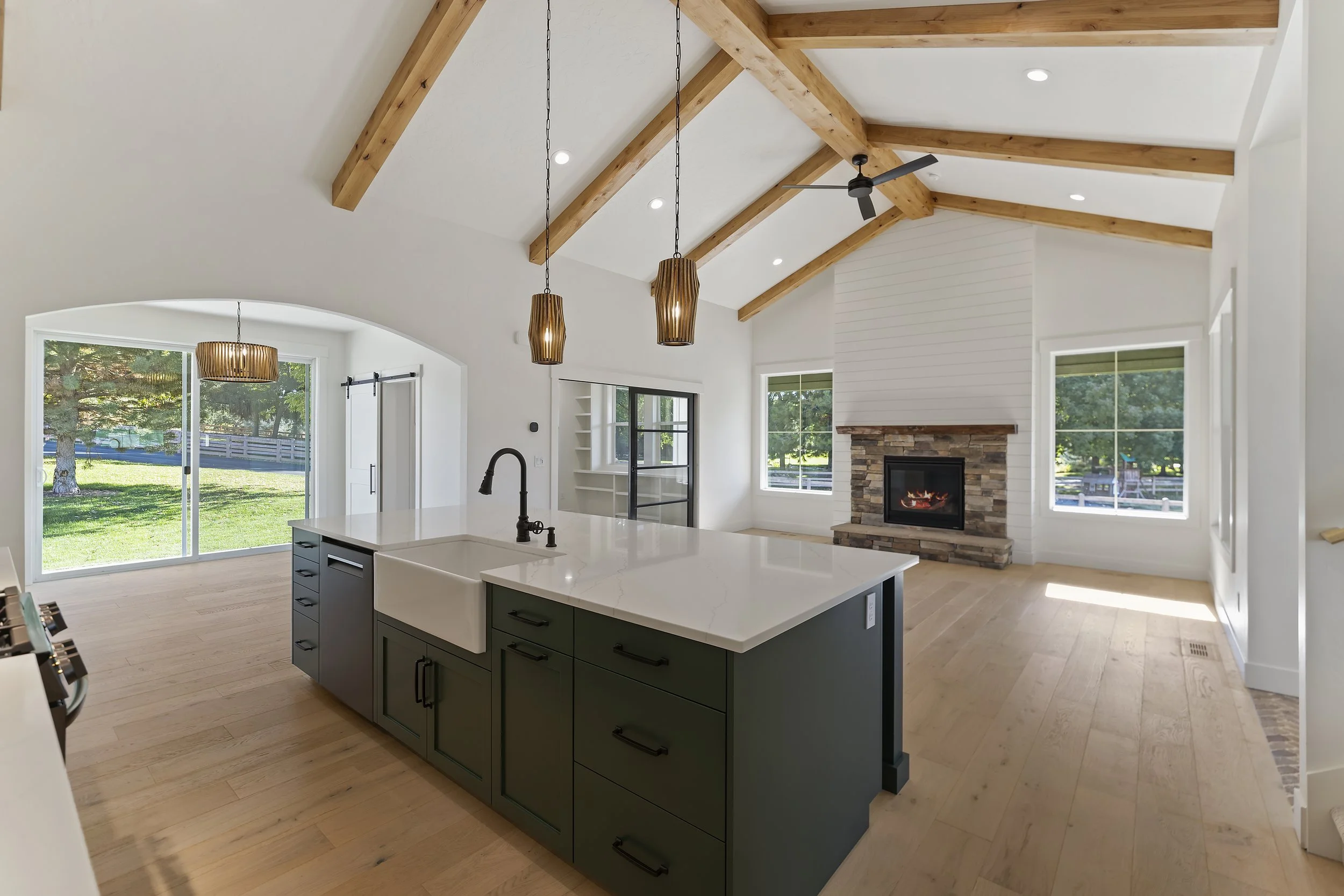 Custom Built home showcasing a farm sink on an island with a fireplace