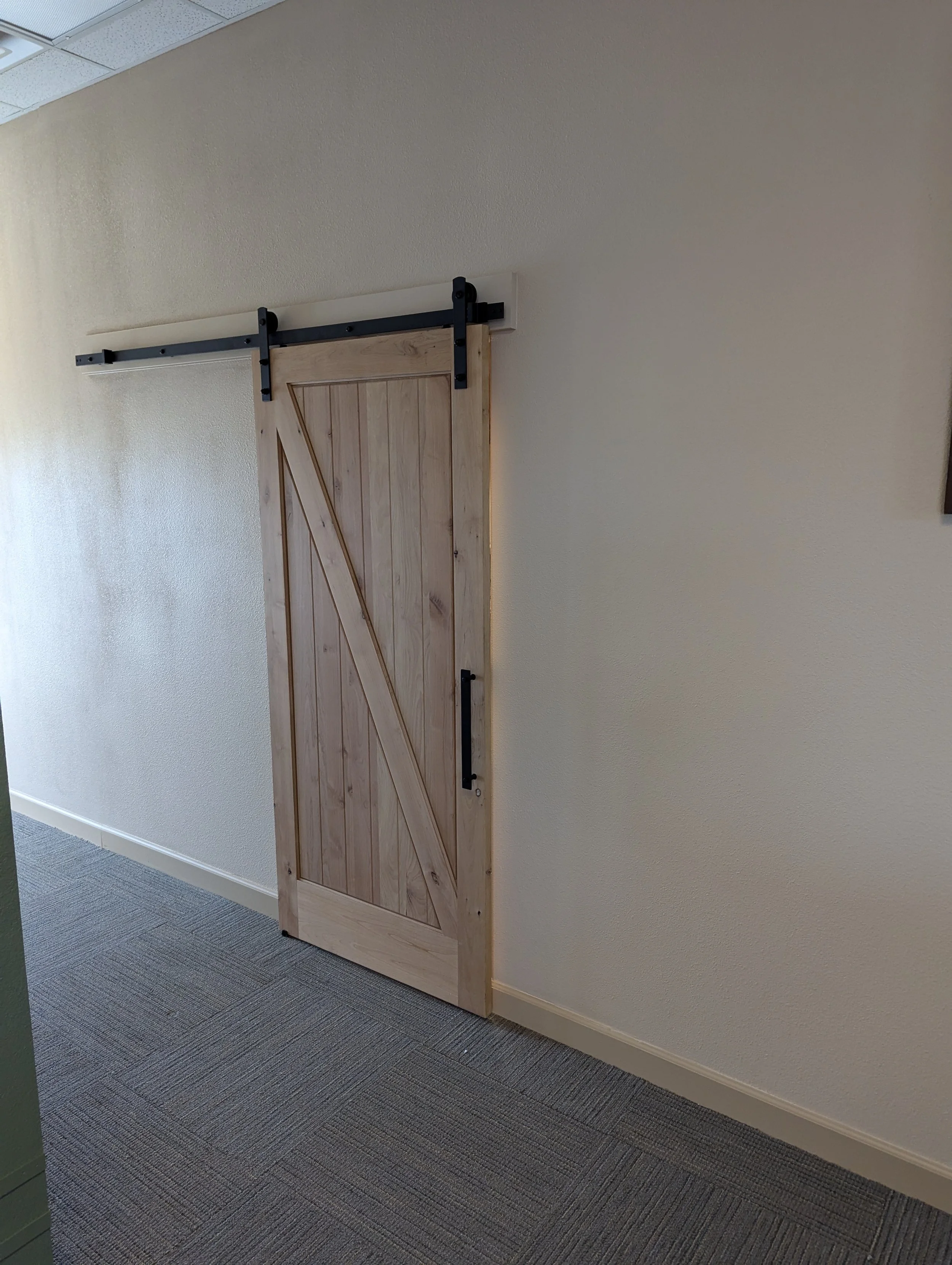 Office break room remodel in Boise Idaho with sliding barn door and custom finishes by tenant improvement contractor