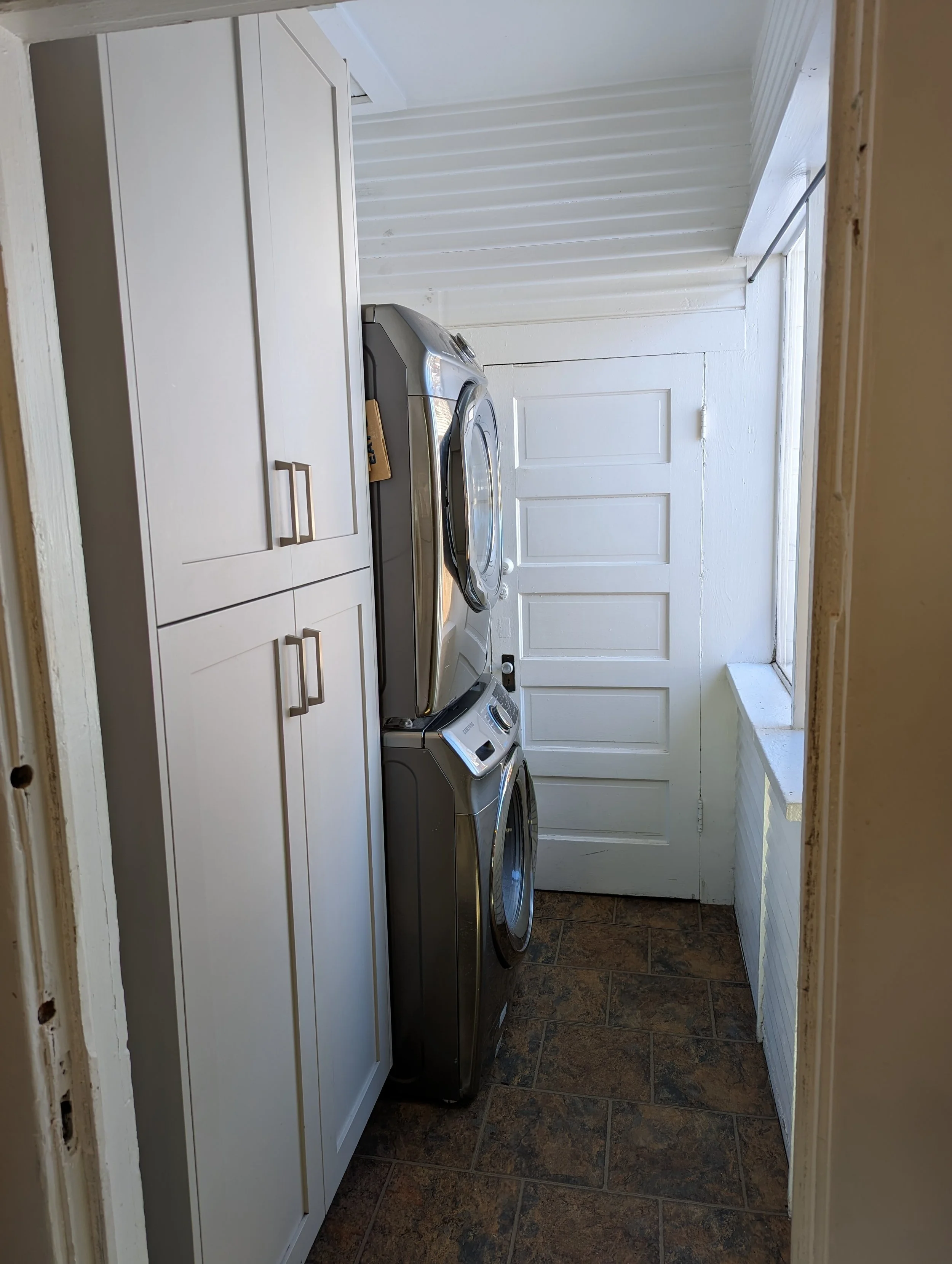 Compact laundry room remodel in Boise Idaho with stacked washer dryer and custom storage cabinetry