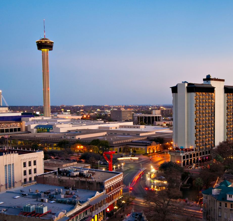Cityscape of San Antonio, Texas featuring the observation tower, and surrounding buildings during dusk.