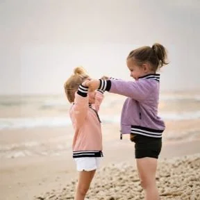 Two girls dancing on beach