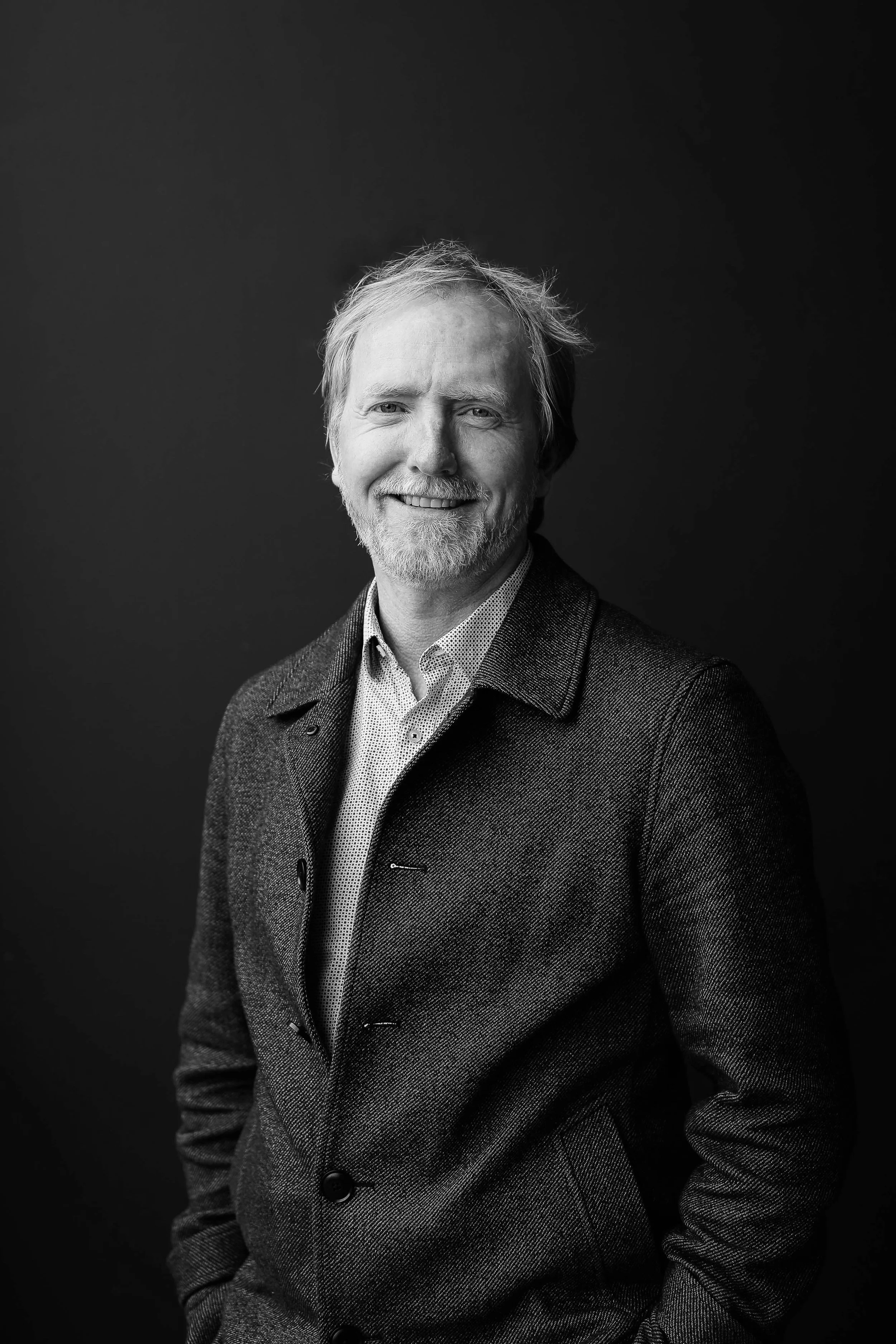 A black and white portrait of Karl Meyer against a dark background