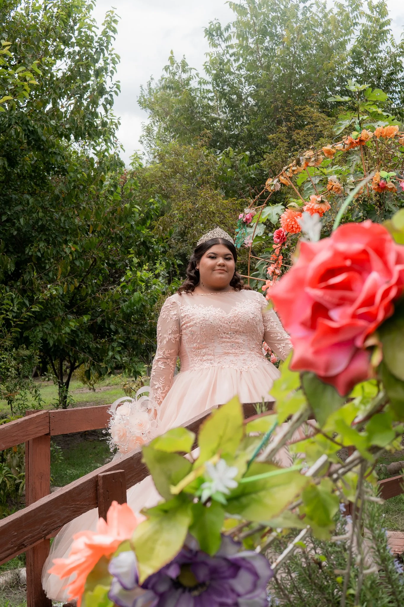Joven en vestido de novia en un entorno de jardín con flores coloridas.