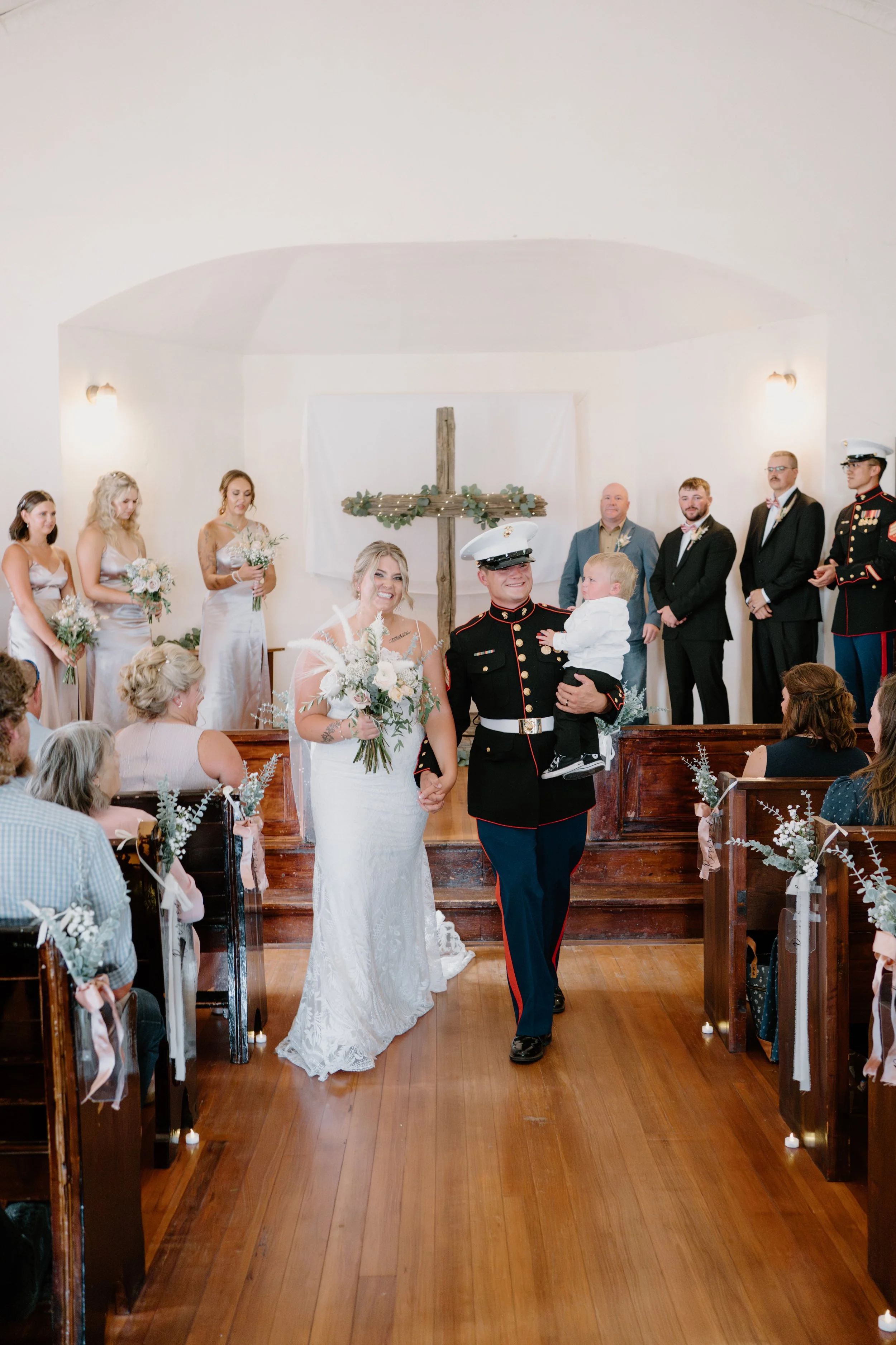 A wedding ceremony with a bride and groom celebrating as they exit married.