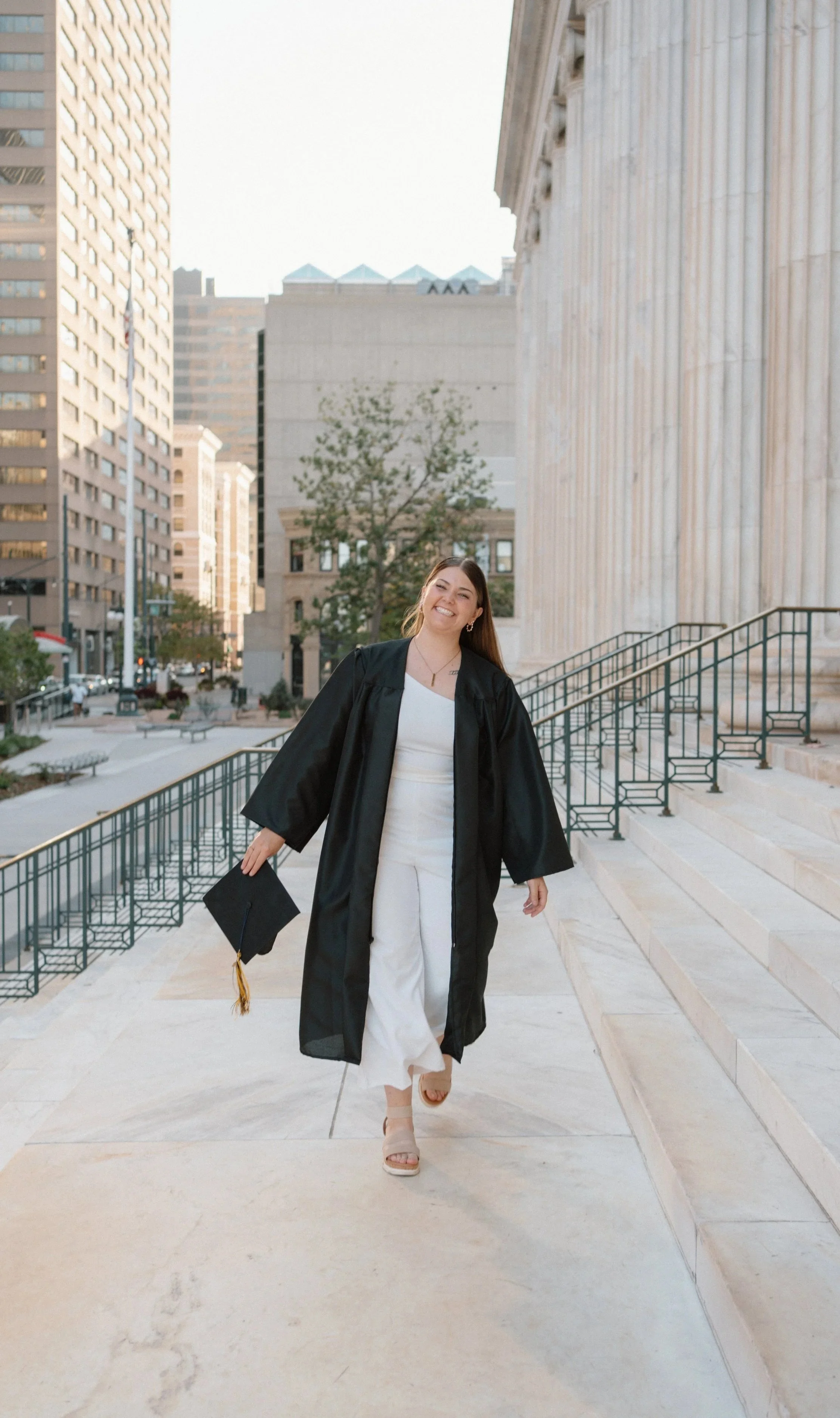 Graduate walking down courthouse steps during a senior photography session.