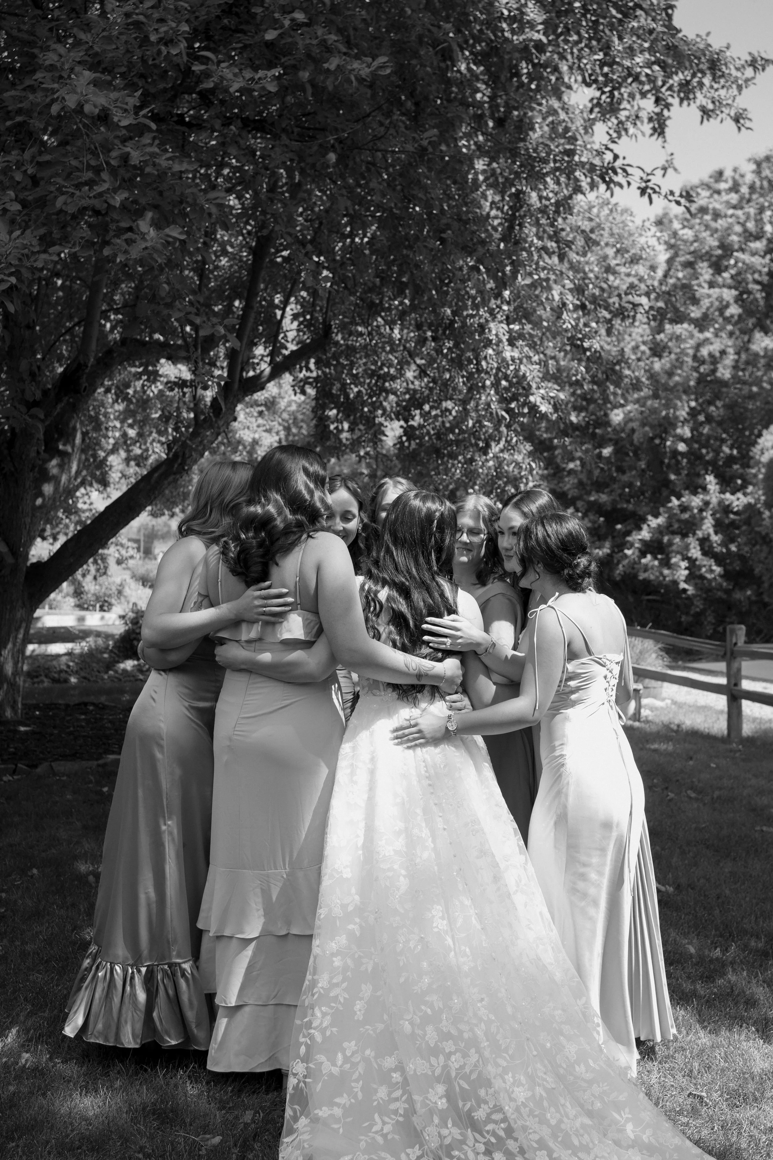 A bride and her bridesmaids sharing a sweet moment after the bride did a dress reveal.