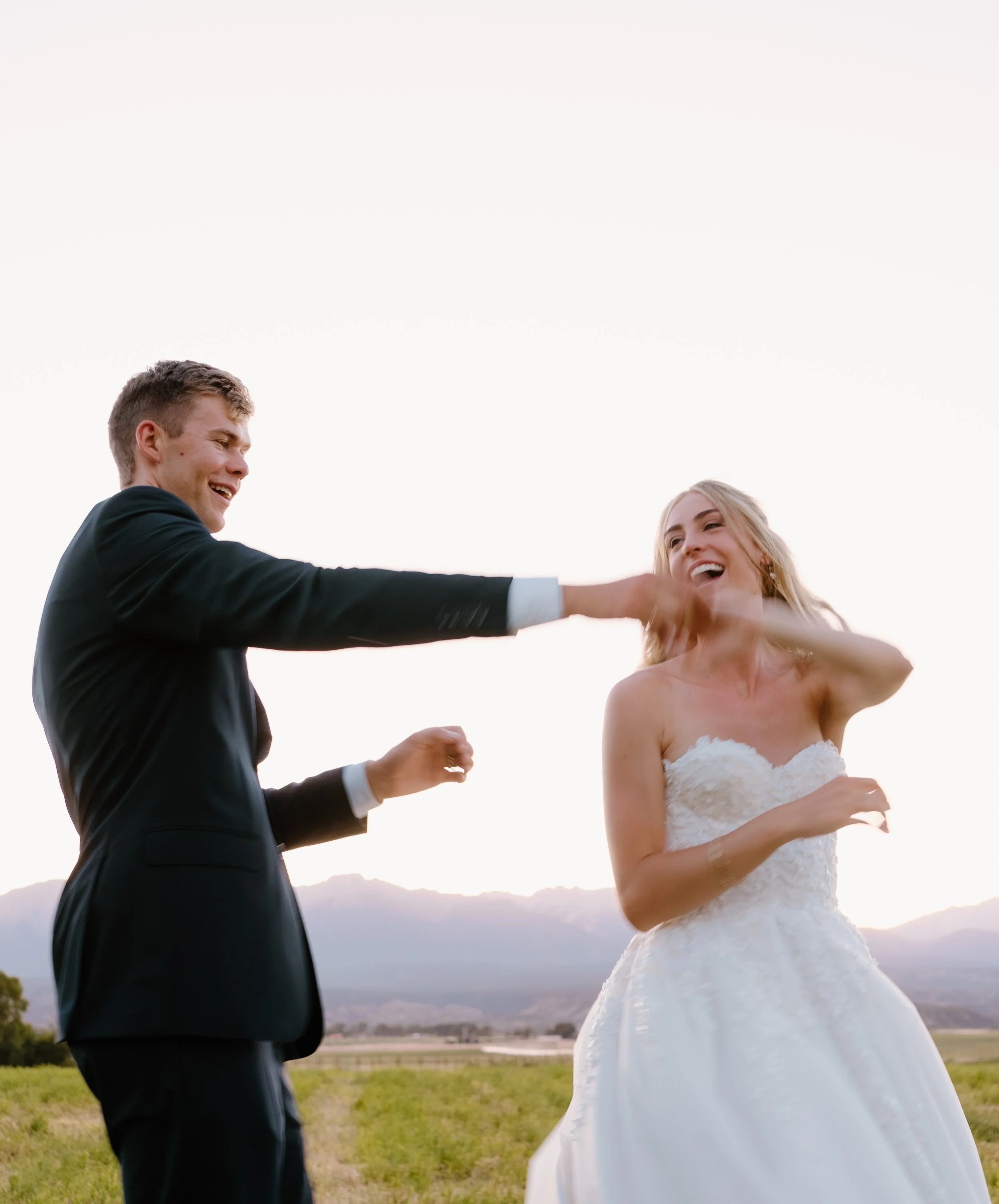 A joyful bride and groom expressing their private vows at sunset, with mountains in the background.
