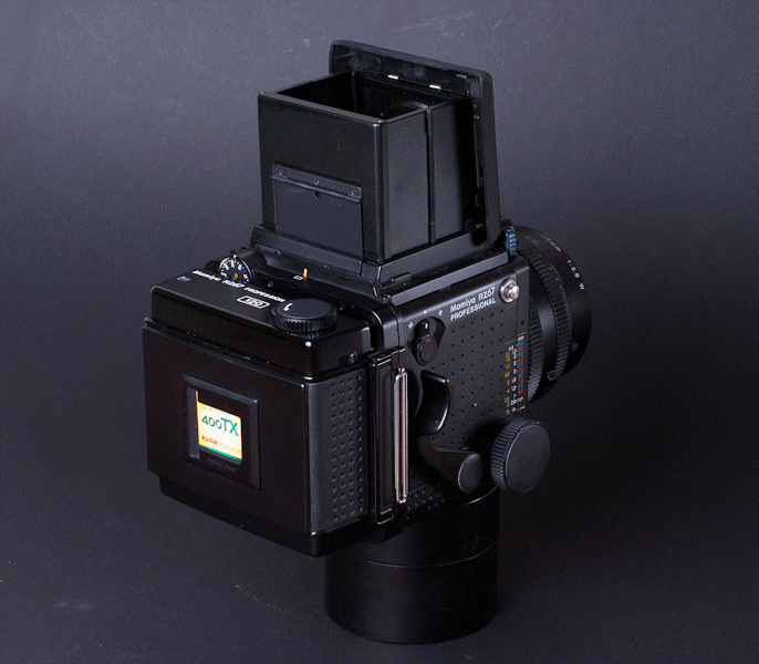 Medium-format film camera with a back-loading film holder and digital display on the back.