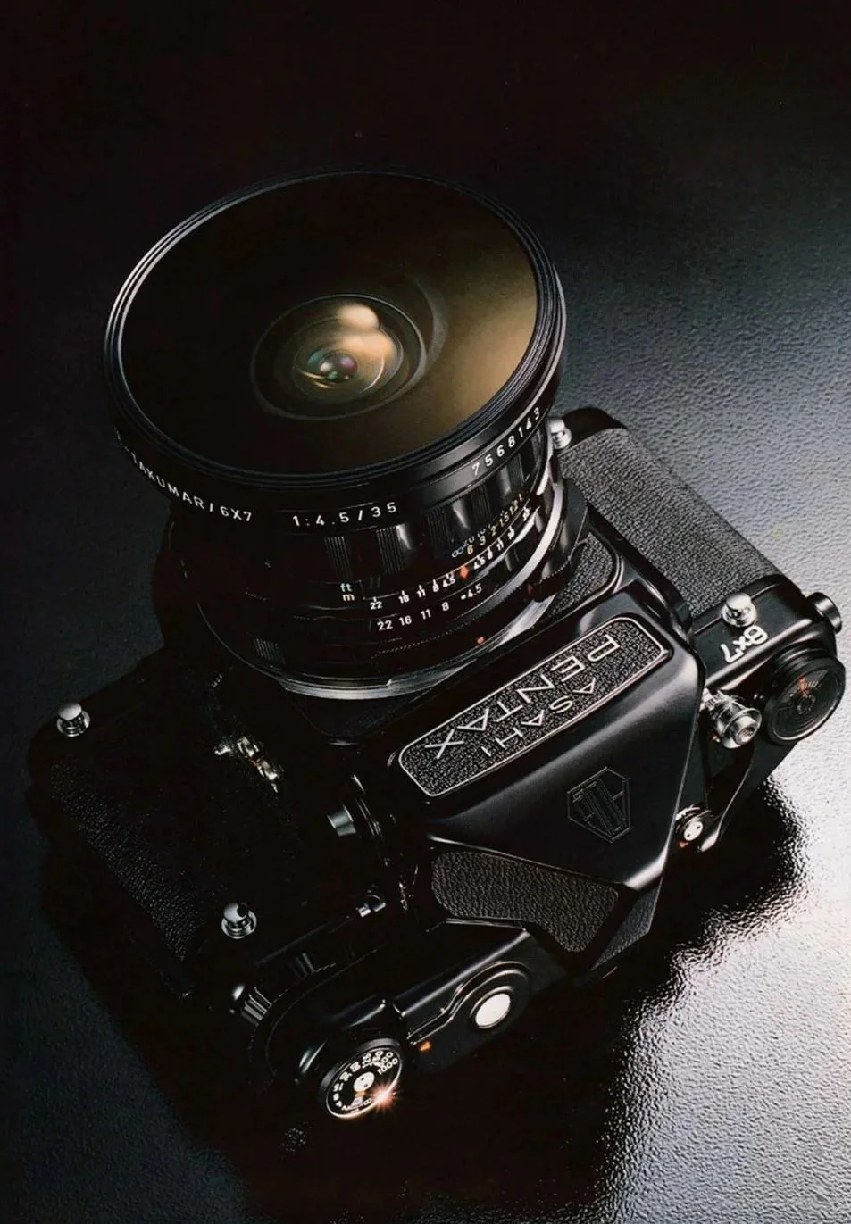 A black vintage film camera with a large lens on a black textured surface