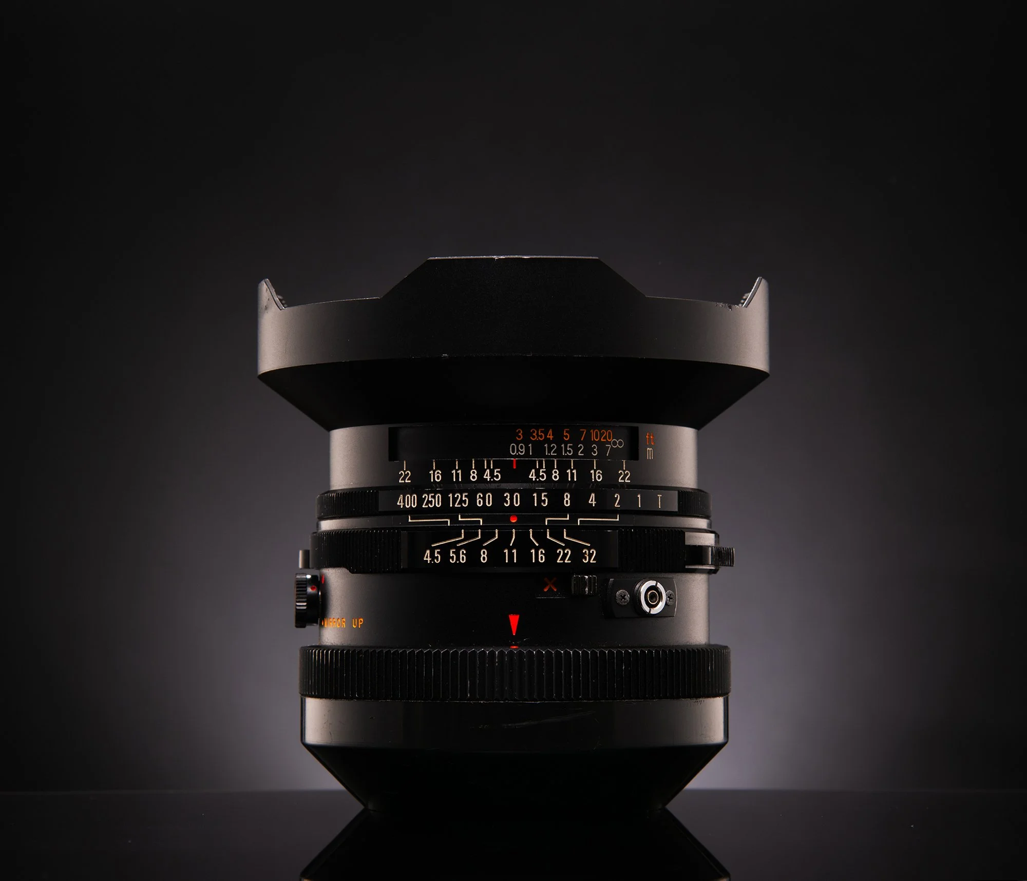 A professional camera lens with various adjustment rings, set against a dark gradient background.