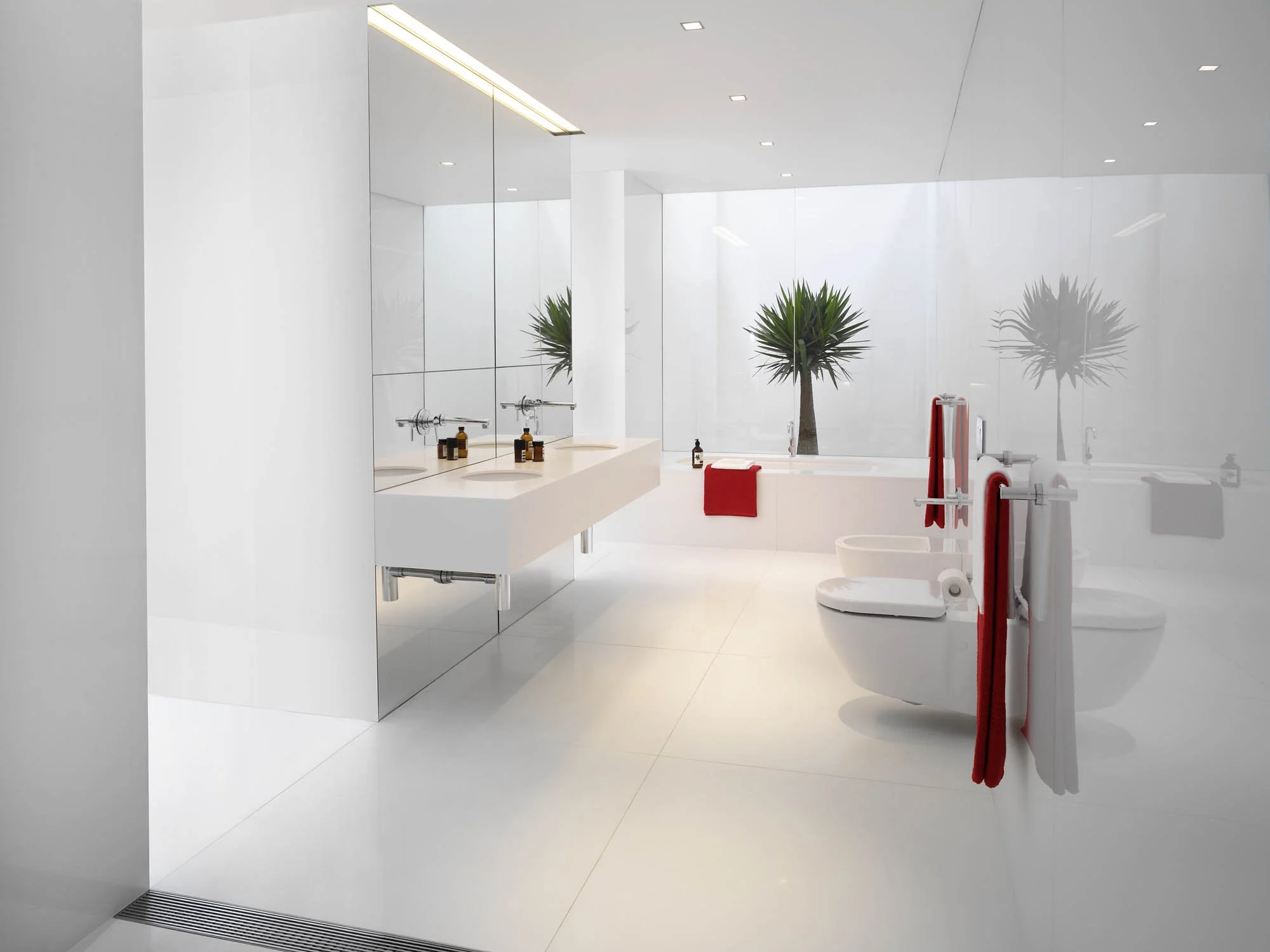 A modern, minimalist bathroom with white walls, floor, and fixtures. It features a double sink vanity with two bottles of soap or lotion, a bathtub with a red towel, and a large window with two potted palm trees outside. Red and white towels hang on 