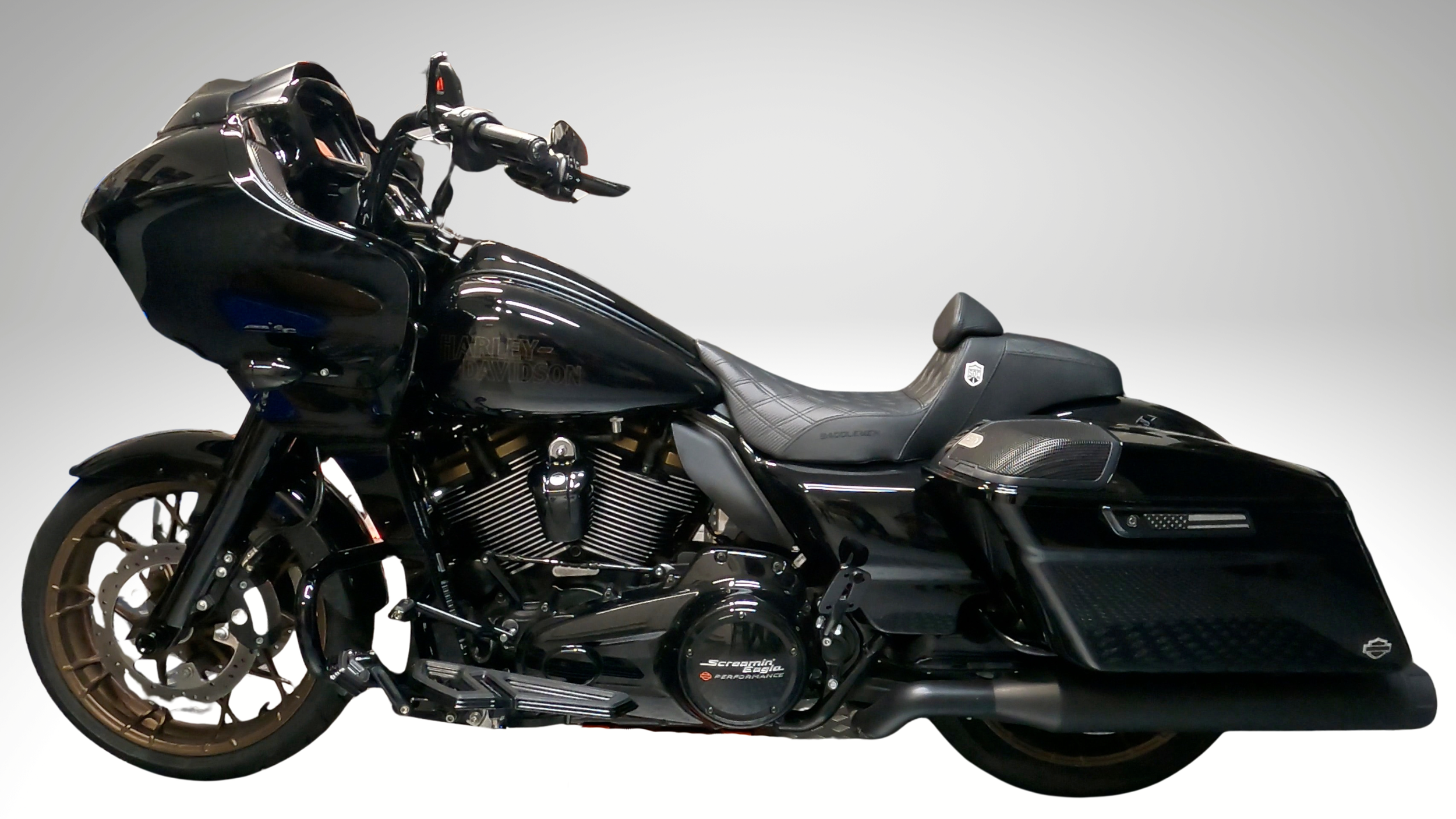 Black Harley-Davidson motorcycle with side saddlebags and a large front fairing, set against a plain background studio style.