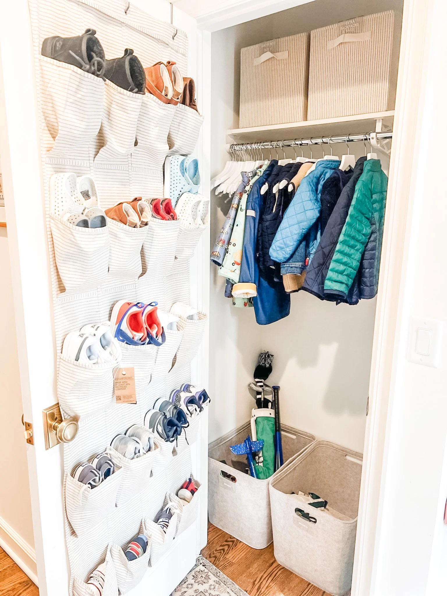 Entryway closet organization uses shoe pockets, labeled bins, and hanging jackets for daily clothing and footwear.