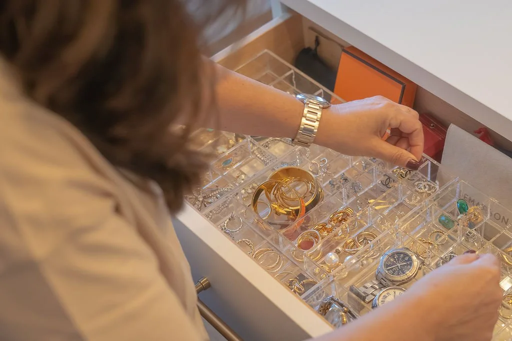 Hands placing accessories into divided storage trays
