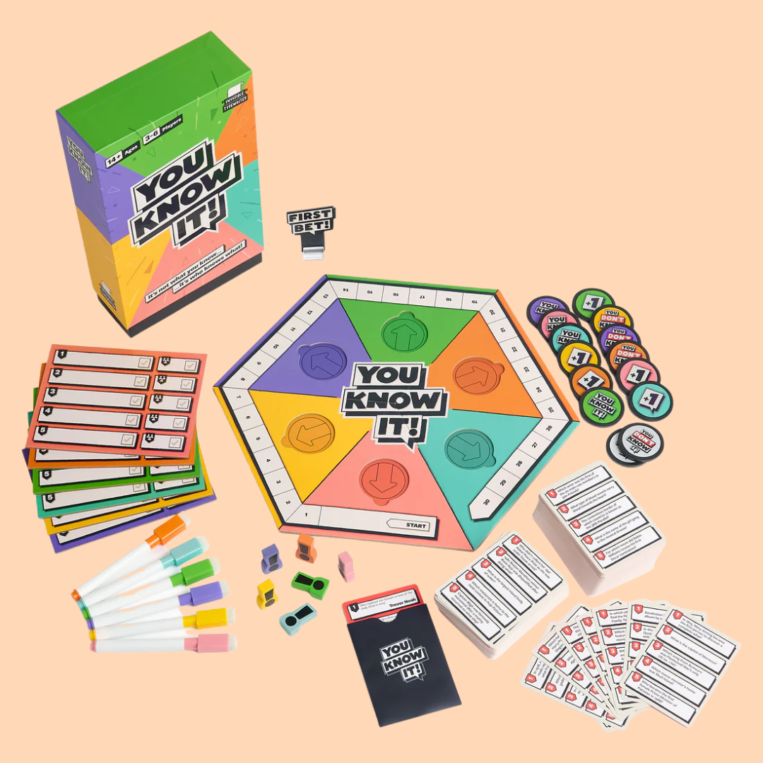 Board game setup for 'You Know It!' with game pieces, cards, markers, and colorful game board on a peach background.
