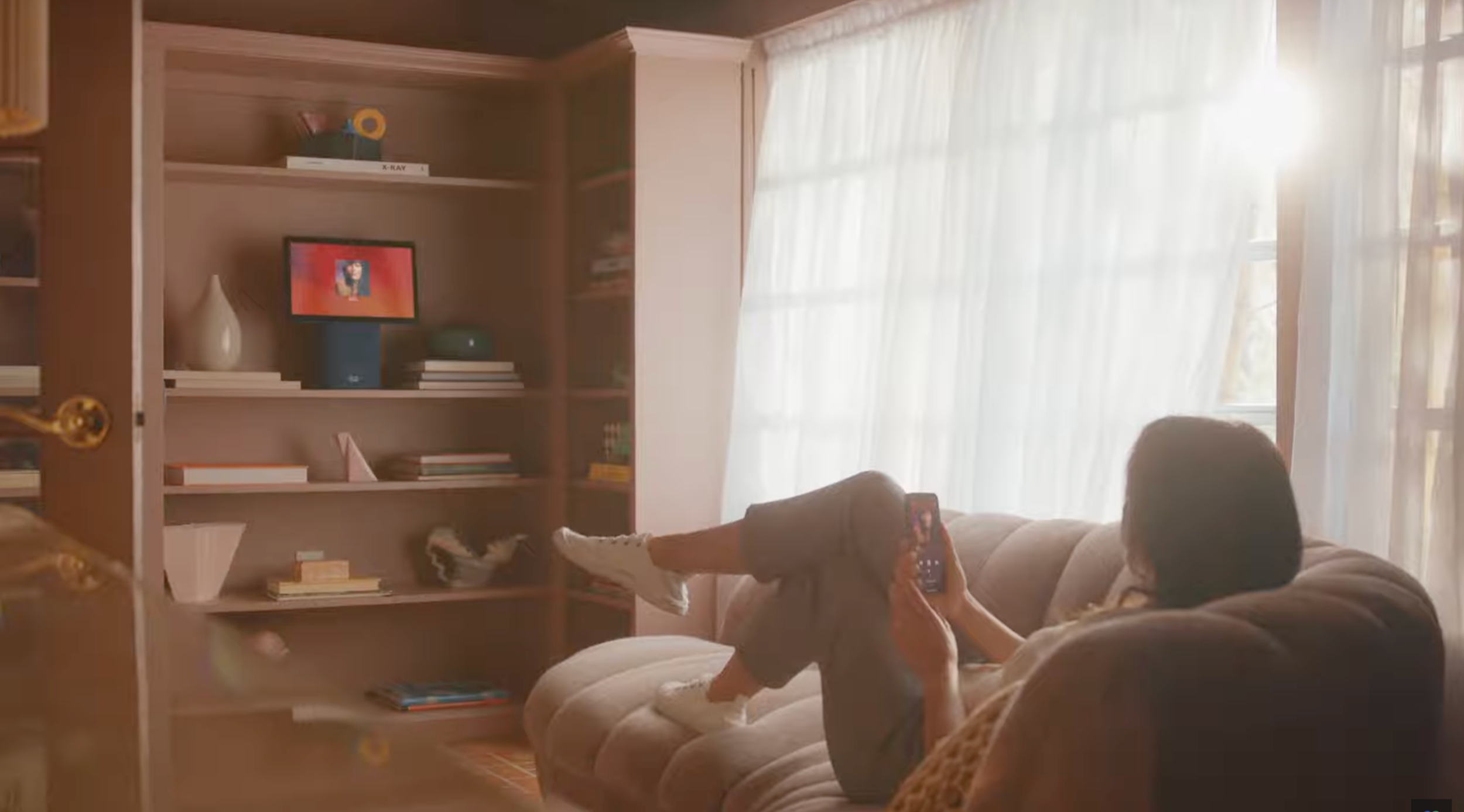 Lifestyle commercial directed by ST Davis for Apple — mother and child on a sofa using a smartphone together in a warm, sunlit living room