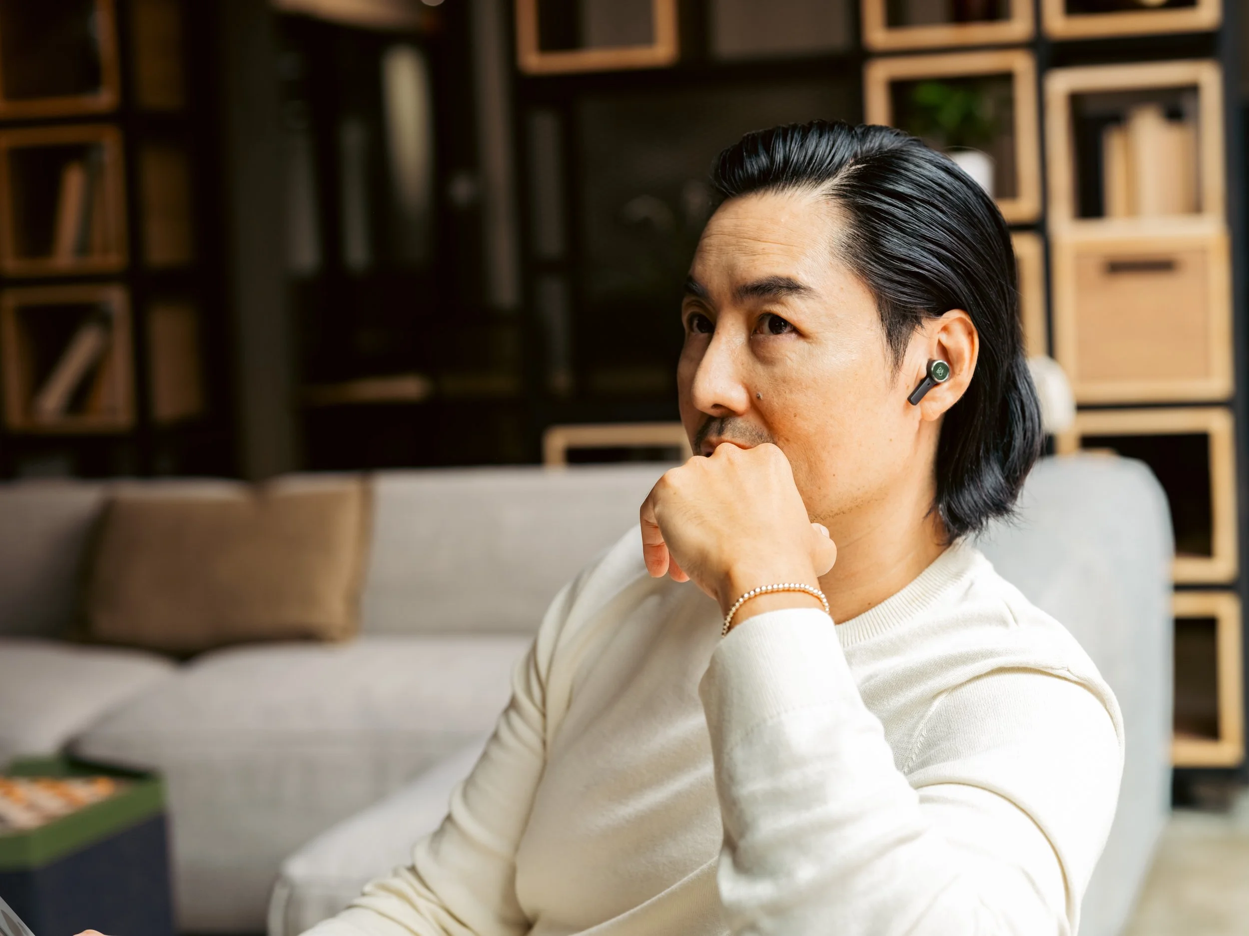 Lifestyle product photography by ST Davis for Bang & Olufsen x Cisco — man wearing wireless earbuds in a warm, naturally lit living room
