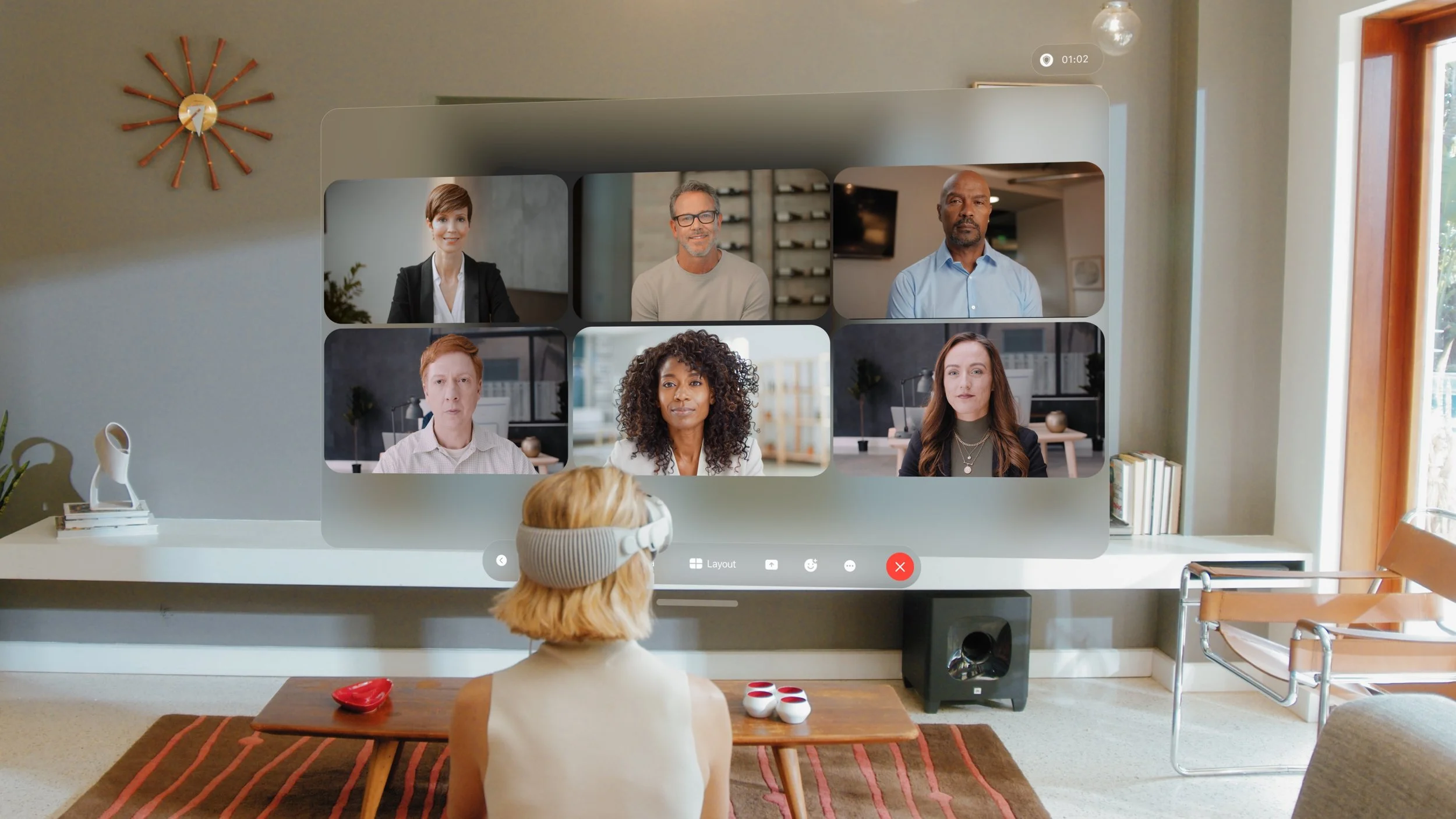 Commercial directed by ST Davis for Apple — woman using headset during a video conference on a large screen in a sunlit living room