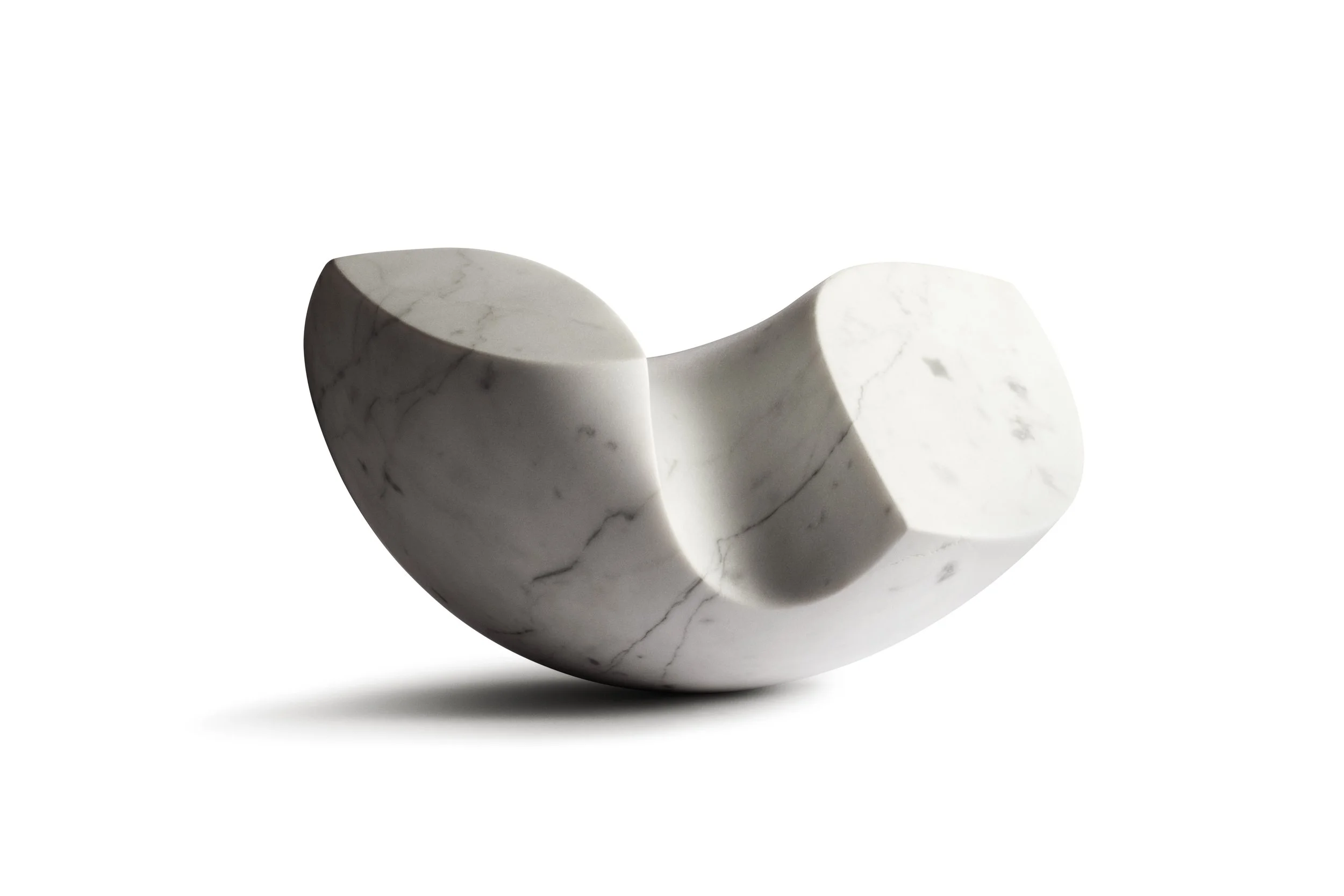 A white marble sculpture with curved, flowing form and gray veining, casting a shadow on a white background.