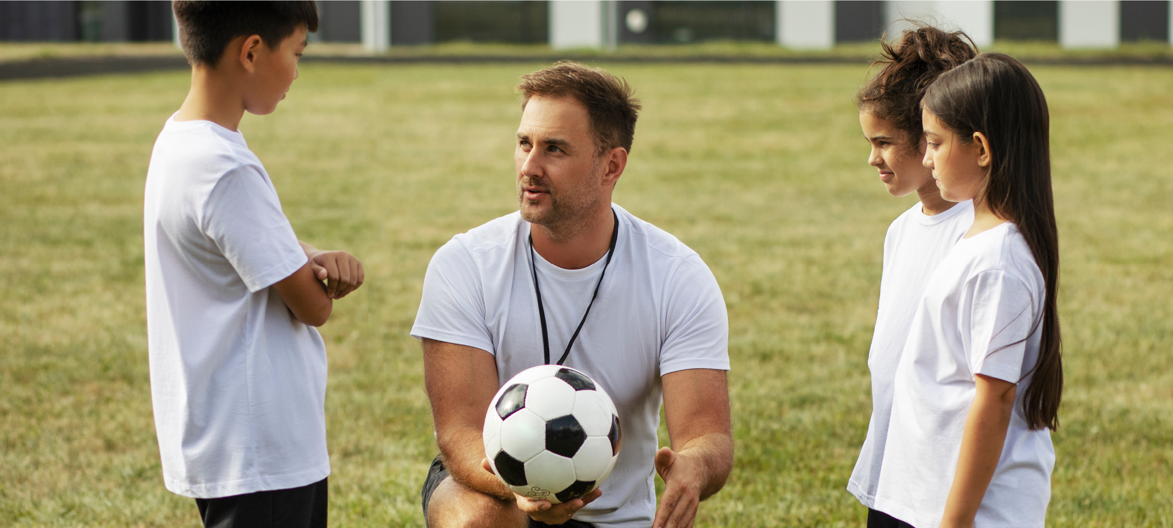 soccer coach talking to a group of kids