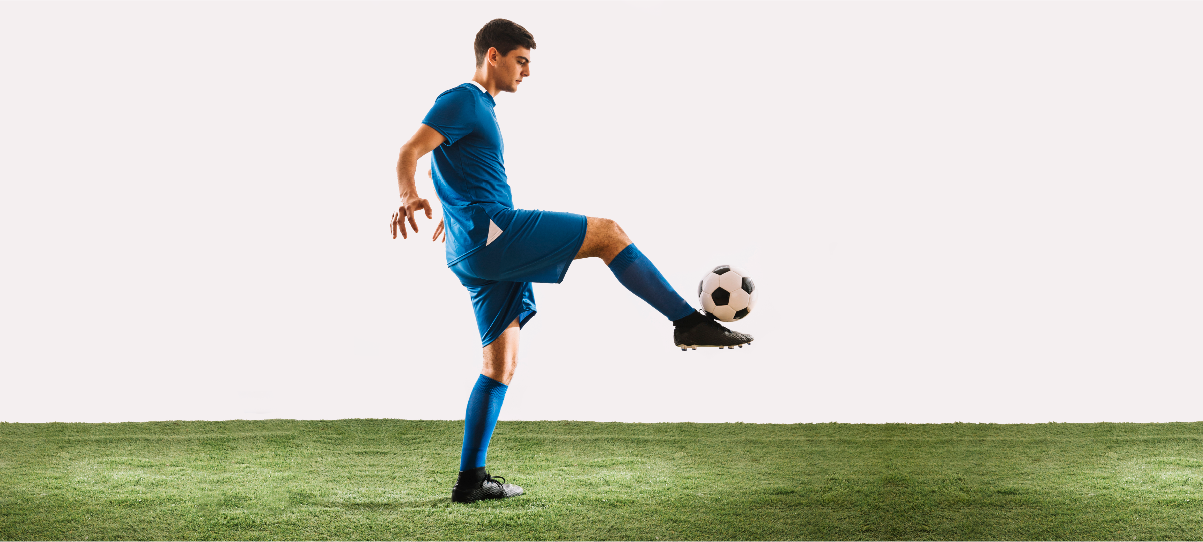 teen boy balancing a soccer ball on his foot