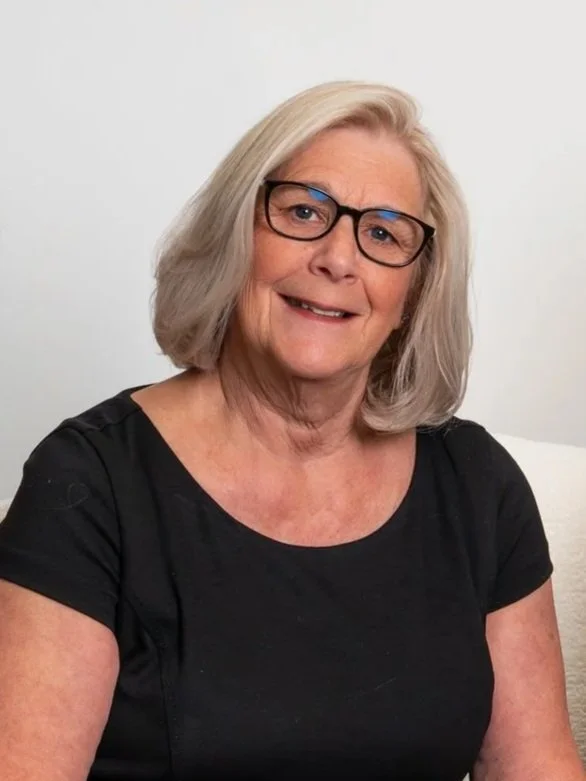 Jo-Ellen Redmond, experienced real estate advisor at Kalman & Co., wearing glasses and a black top, smiling against a white background.