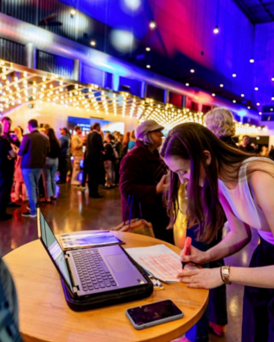 Abbie Sykes, working the check-in desk at a large-scale Brisbane film premiere with over 250 guests.