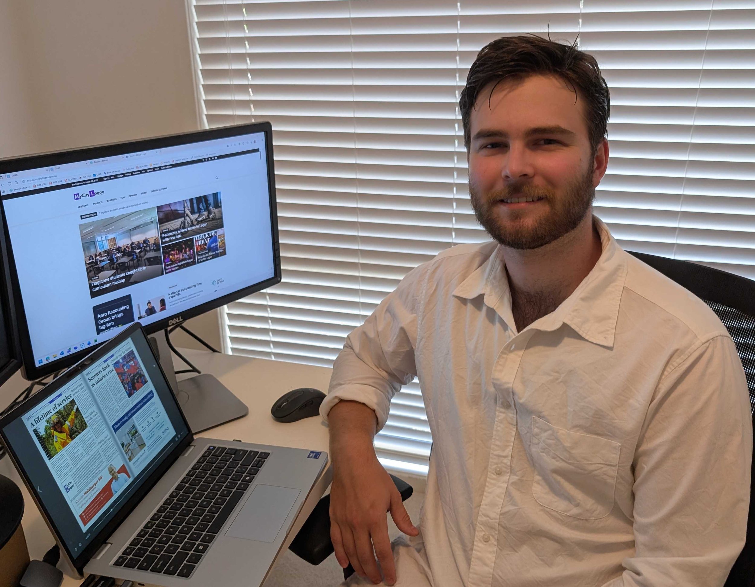 Image of man sitting at desk facing away from computer towards camera