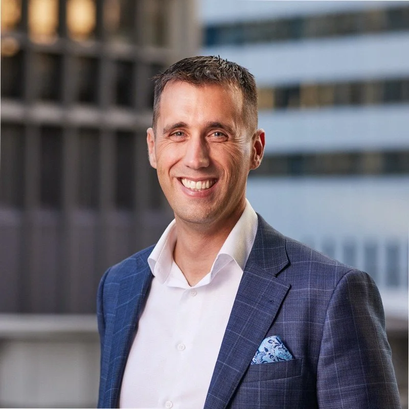An executive man smiling on a blue suit.