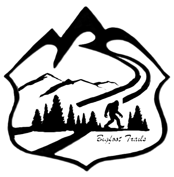 Black and white logo depicting mountains, a winding trail, trees, and a hiker, with the text 'Bigfoot Trails'.