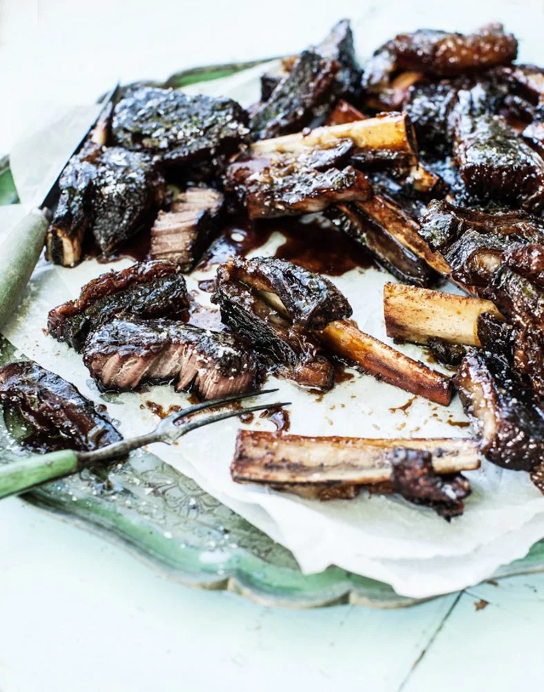 Barbecue ribs on a plate with barbecue sauce and seasoning