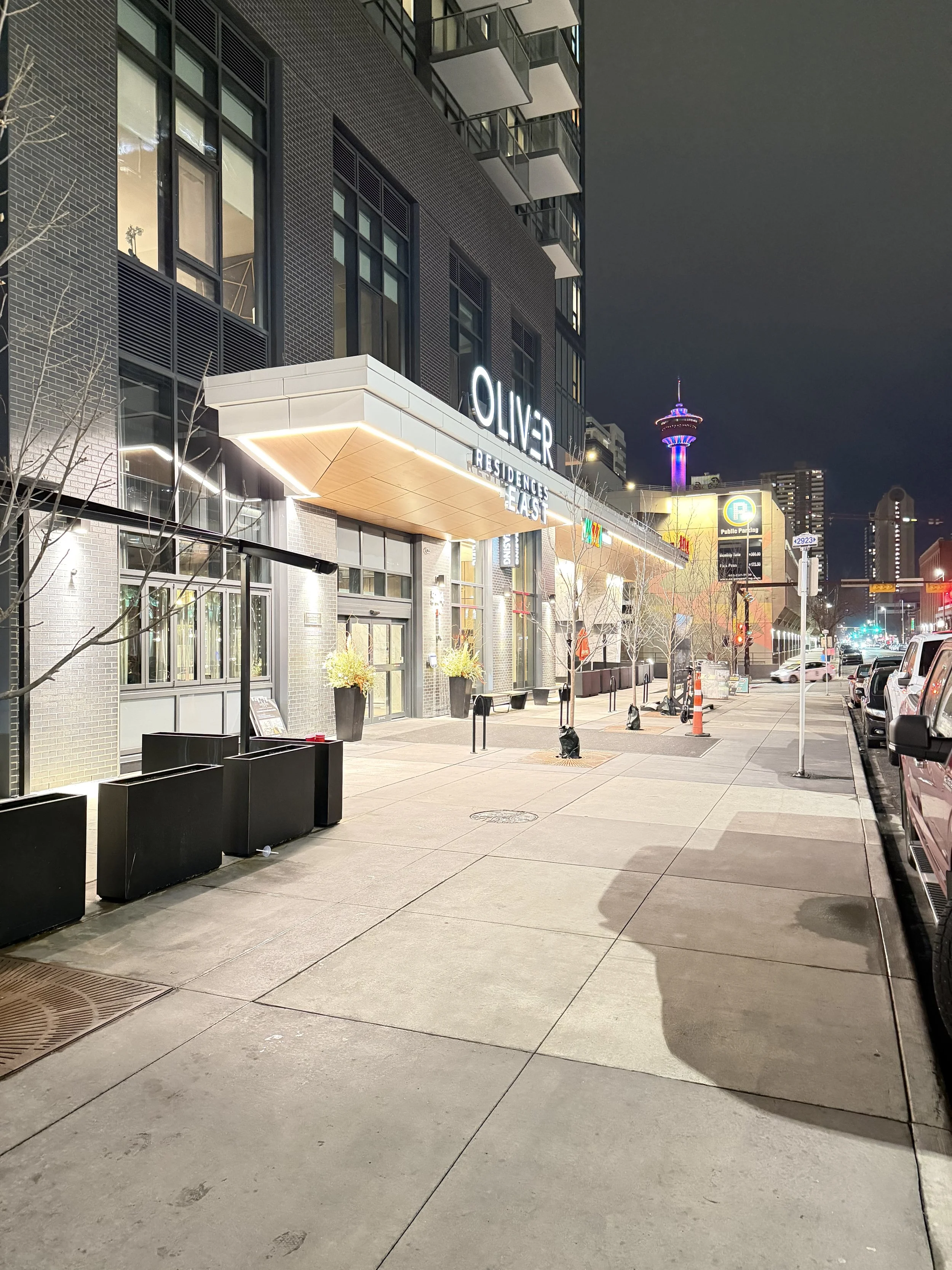Modern multi-story building with Whole Foods Market sign at street level, on a corner of Ash Avenue and University Street in an urban area.