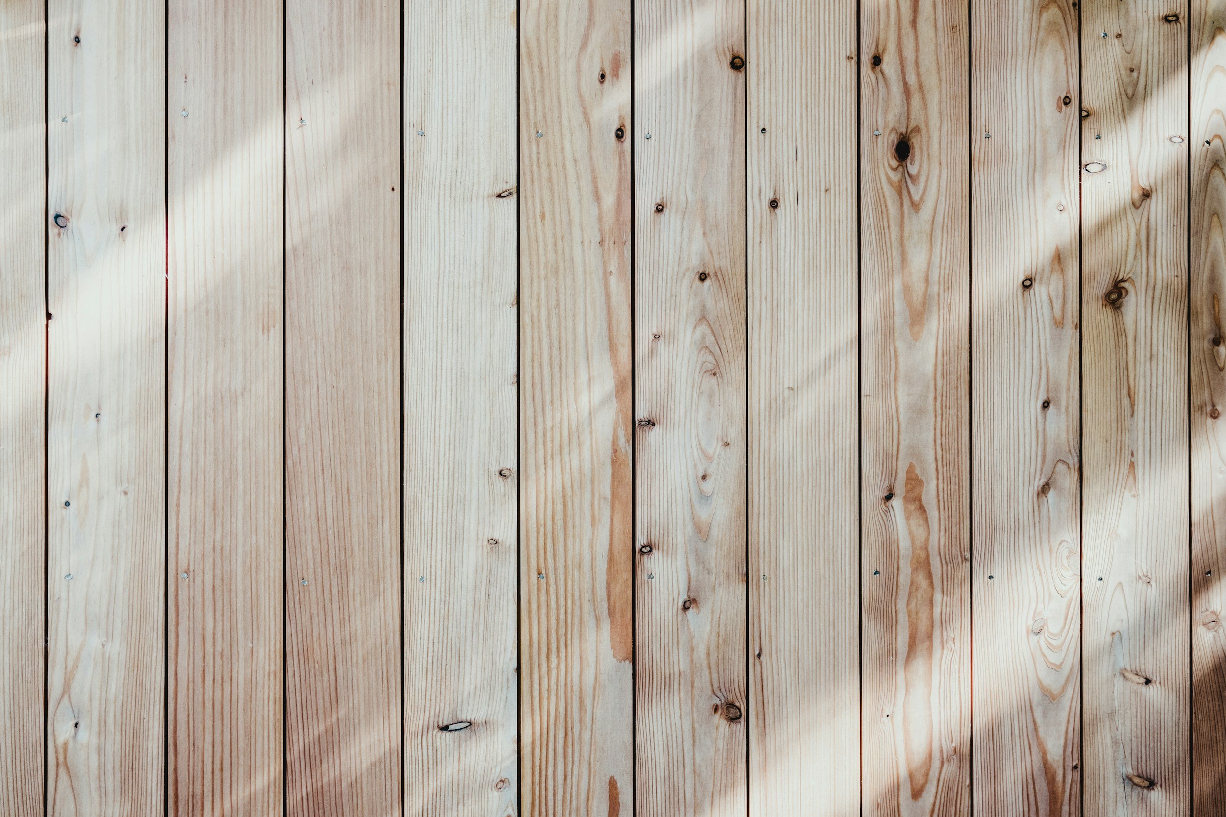 Close-up of wooden planks with natural wood grain, knots, and a light finish.