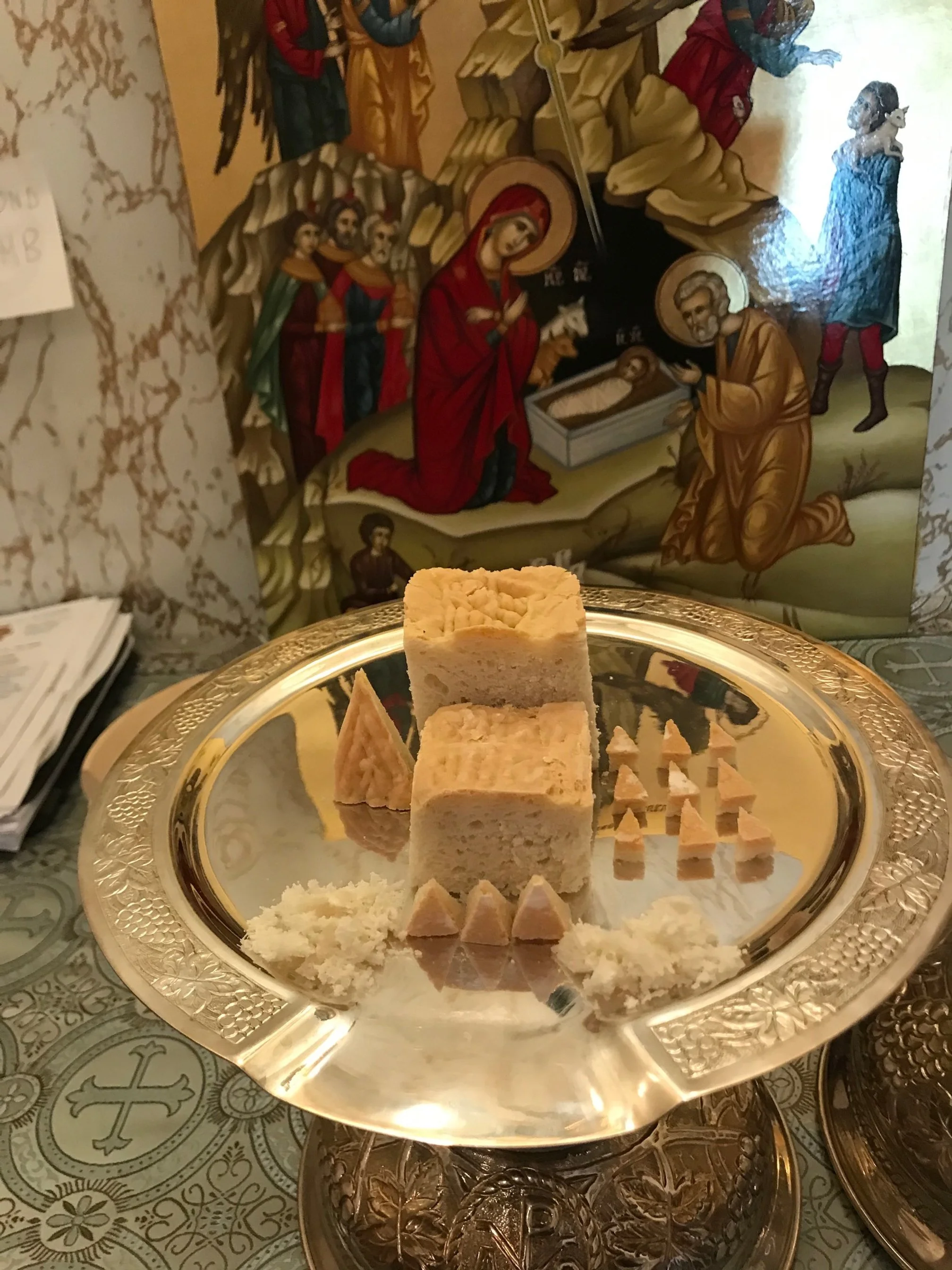 Prosphora bread cut in arrangement for offering with an icon.