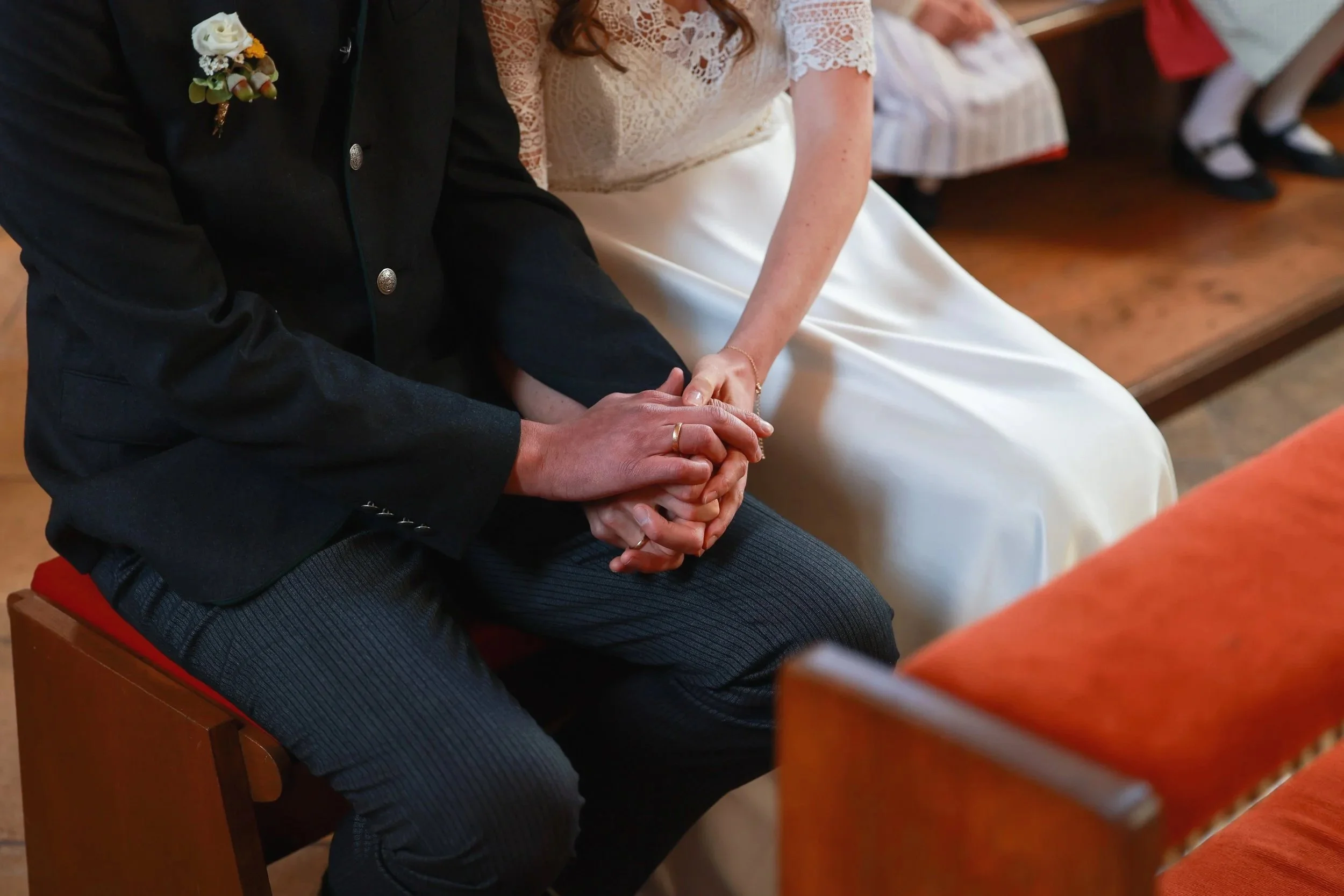 Ein Brautpaar hält bei einer Hochzeit die Hände miteinander. Hochzeitsfotografie