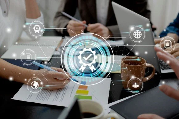 A meeting table with people using laptops and tablets, and a graphic overlay of digital icons representing data, charts, and technology.