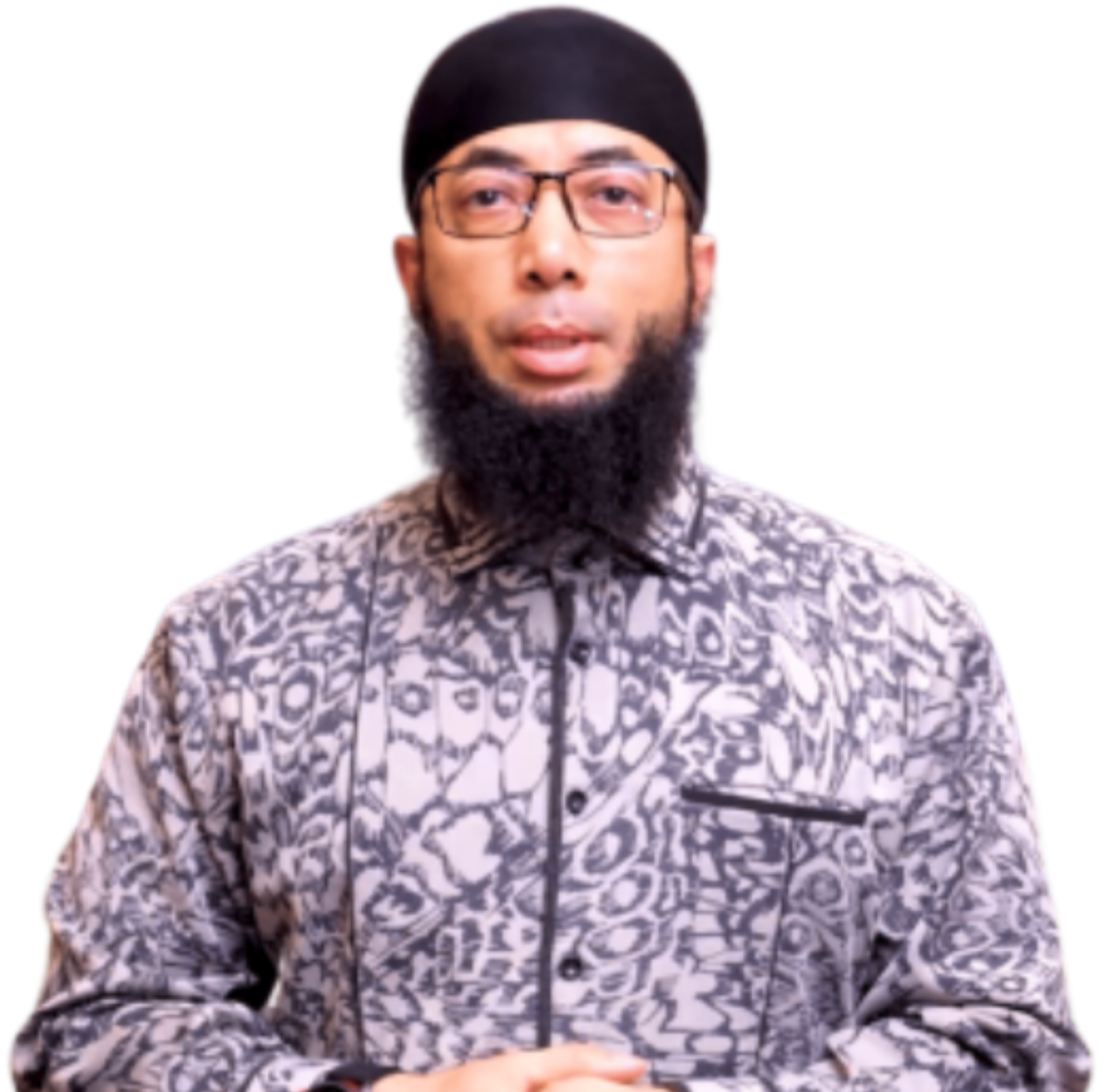 A young man with glasses, a black beard, and wearing a black cap and patterned shirt.