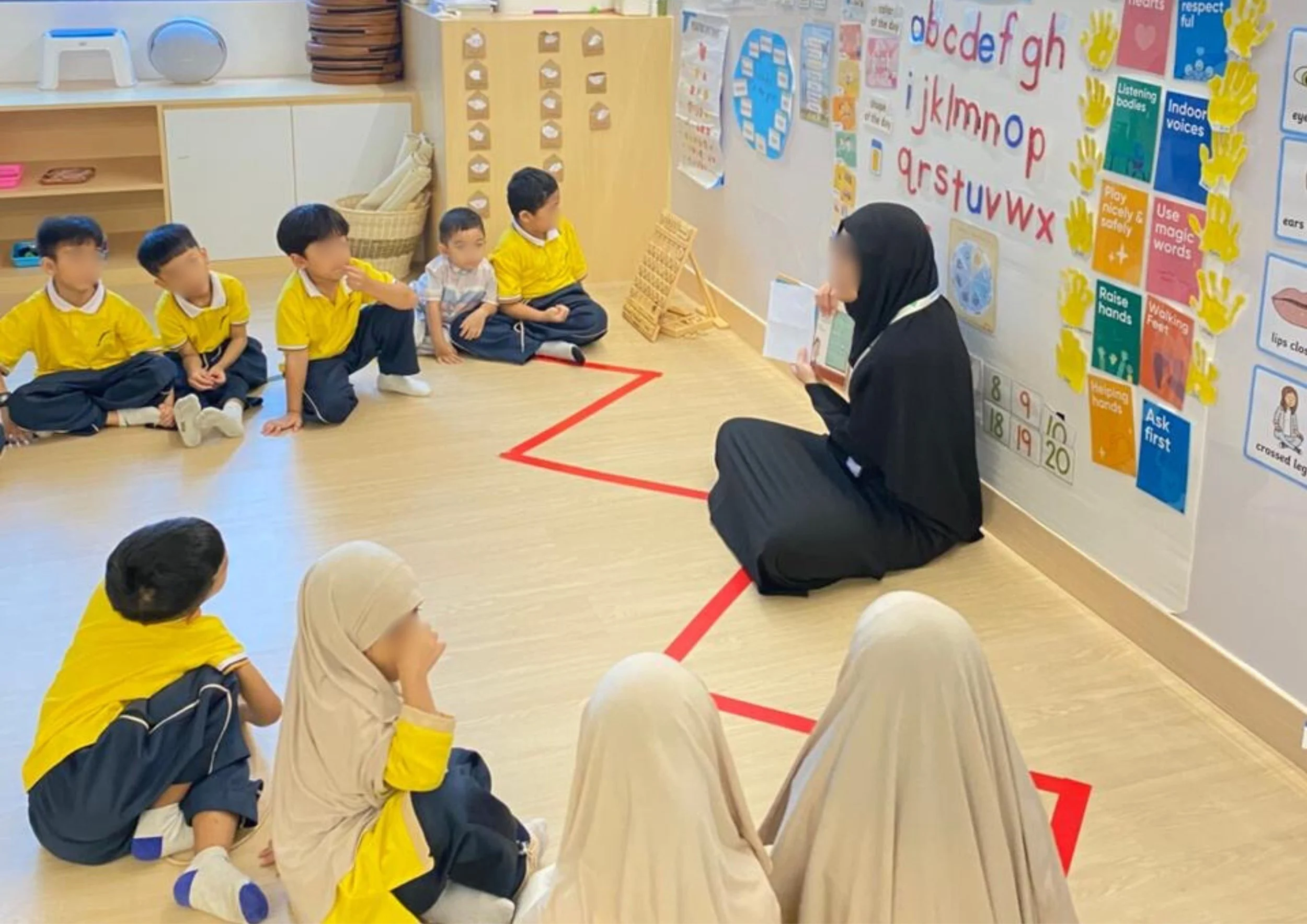 A teacher sitting on the floor reading to young children seated on the floor in a classroom.
