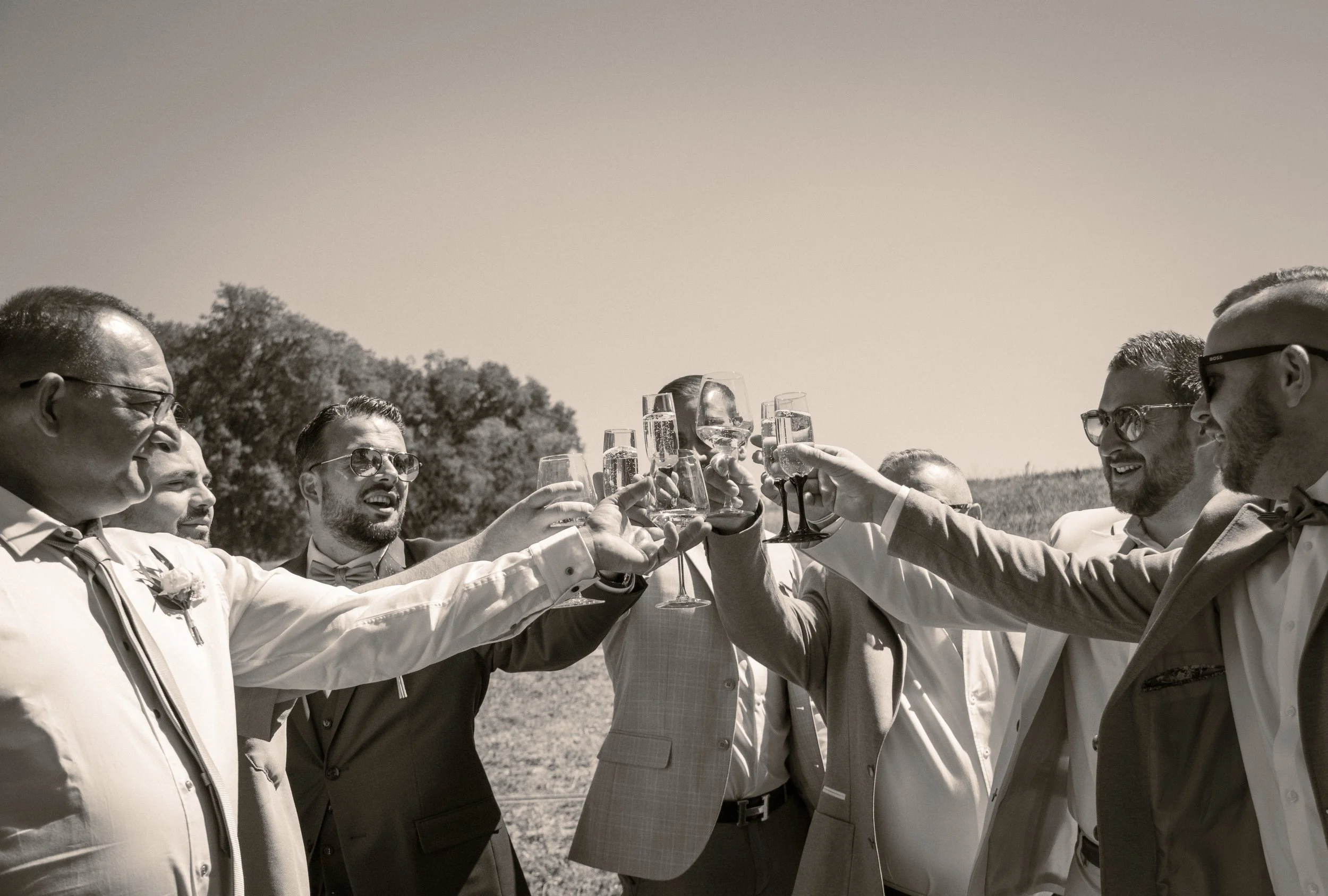 Groupe de personnes célébrant avec des verres de champagne lors d'une occasion spéciale en plein air, apparentée à un mariage ou une fête
