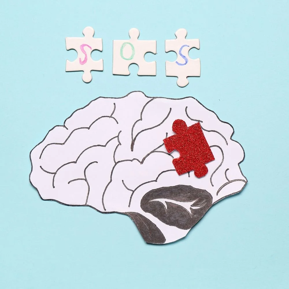 Zeichnung eines menschlichen Gehirns mit einem roten Puzzleteil darin und drei Puzzleteilen darüber, die die Buchstaben S, O, S in verschiedenen Farben zeigen.