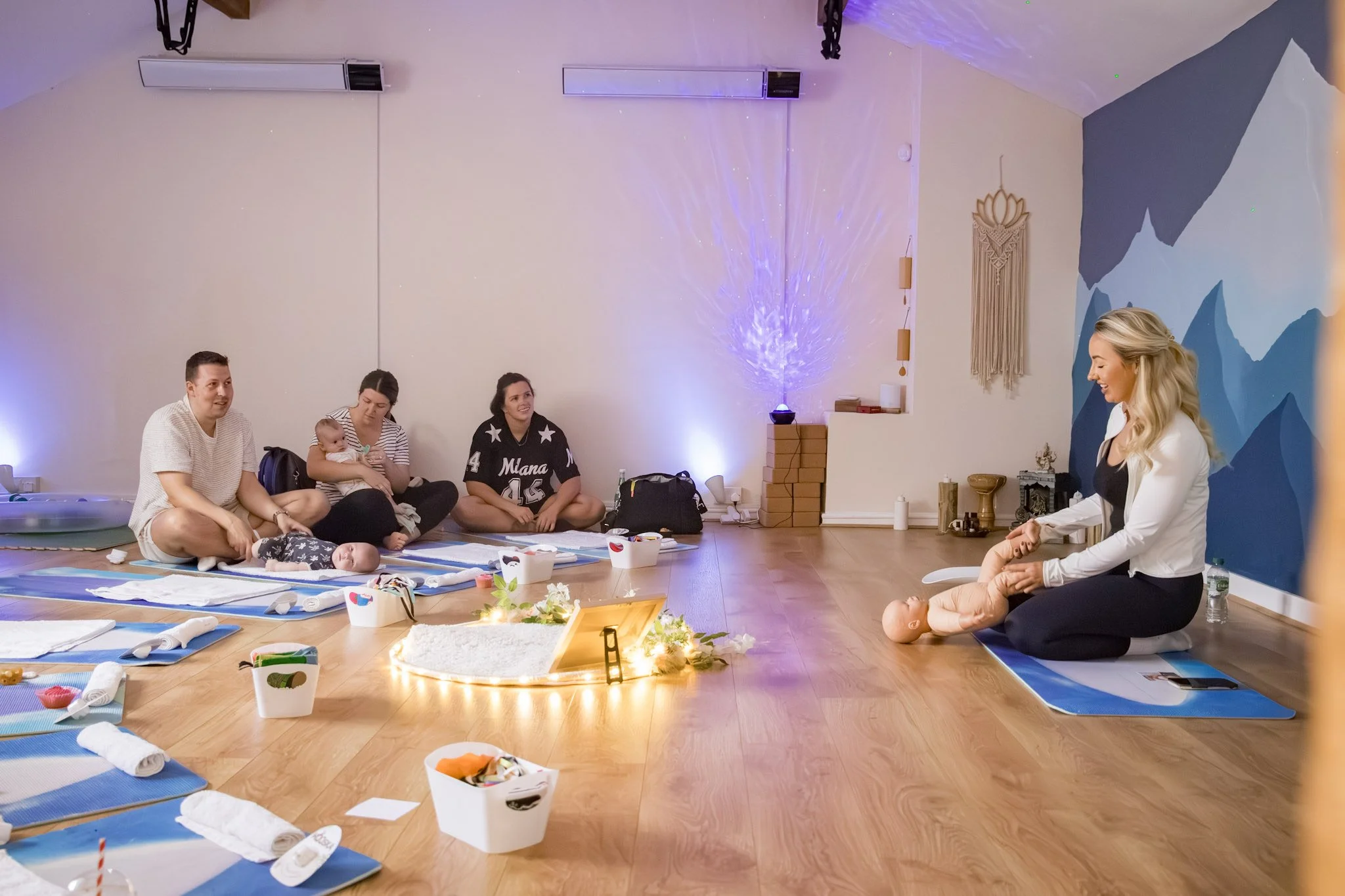 Our baby specialist Nicole hosting a baby massage class with parents and children joining in