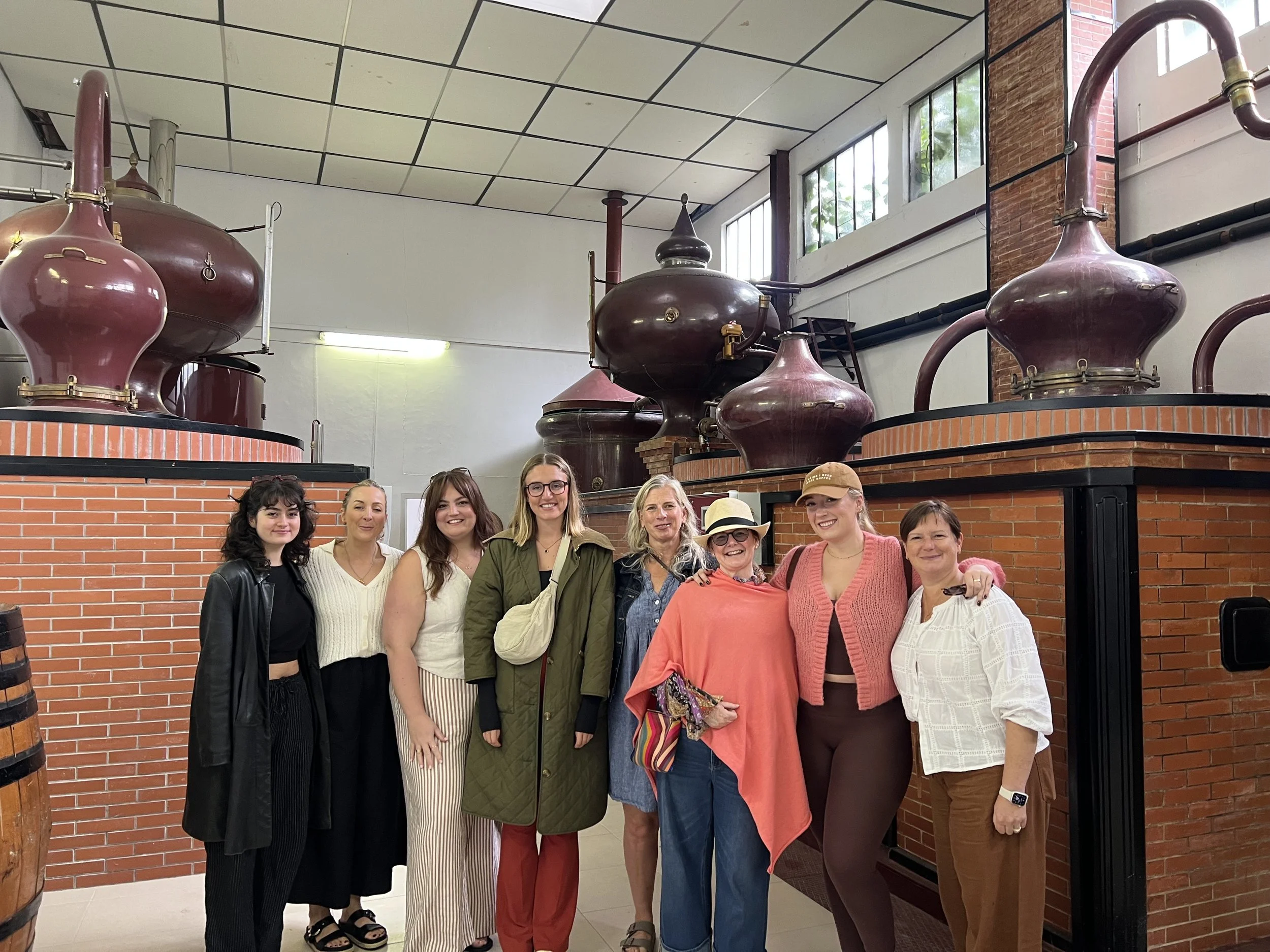 A group of women of all ages at a Cognac distillery one of the excursions on a Satya Sanctuary retreat