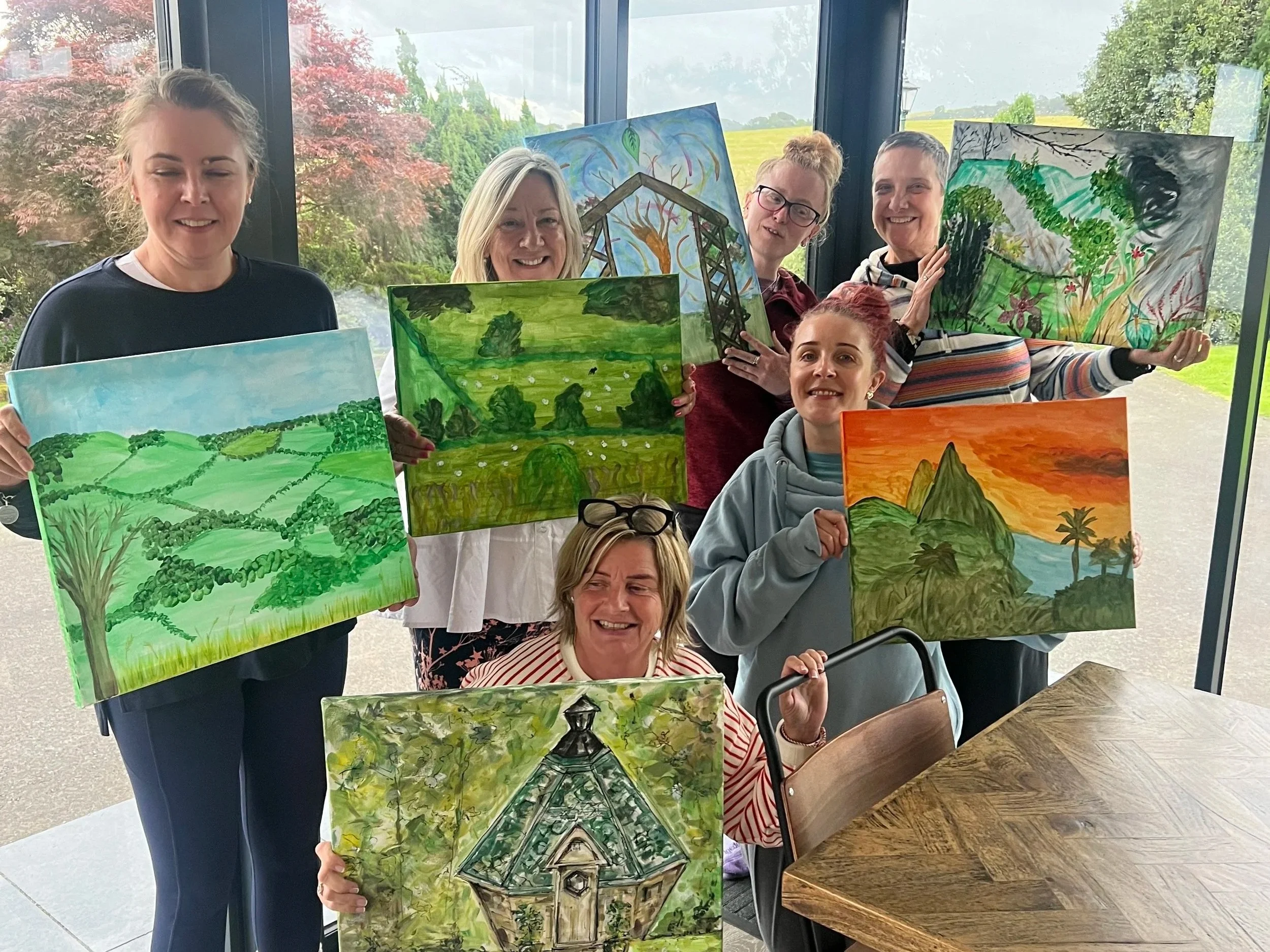 A group of women showing their artwork they created on a Satya Sanctuary retreat