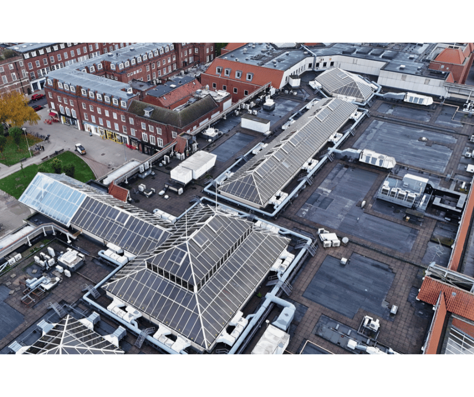 Aerial drone view of commercial building rooftops showing flat roof sections and HVAC units during Ovrsite building inspection